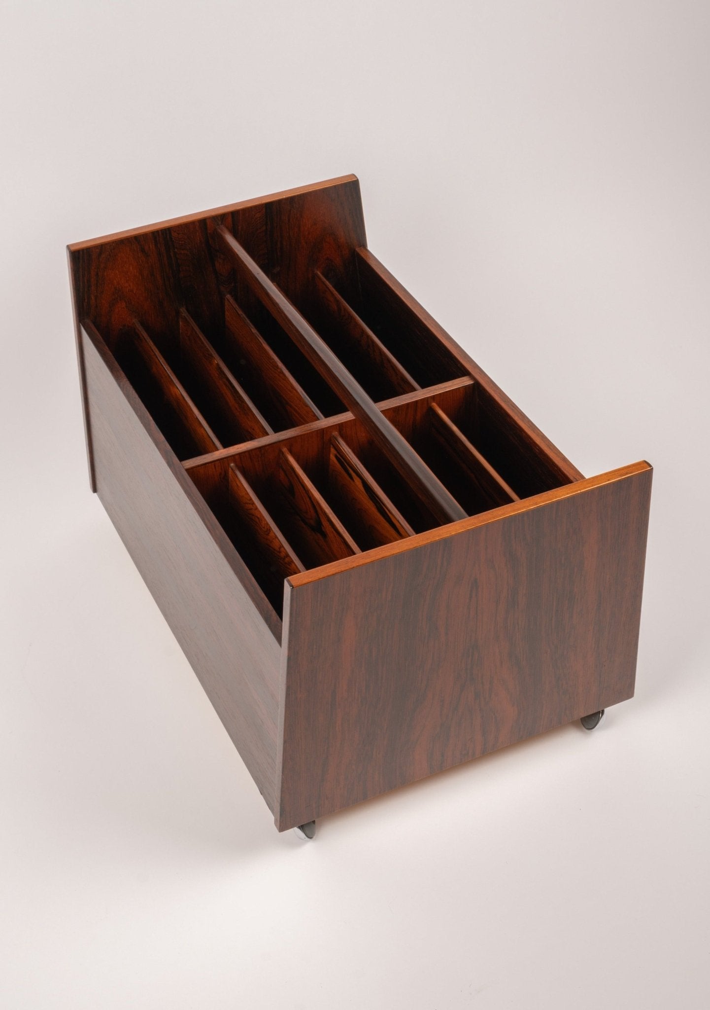 Bruksbo rosewood rolling cart with divided compartments for magazines or records and castors for mobility on white background
