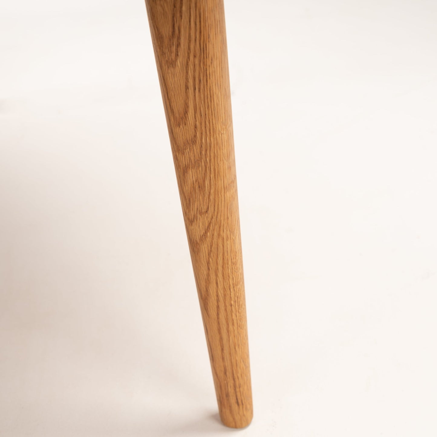 Danish Butterfly-Leaf Teak Dining Table closeup of a tapered teak leg showing warm wood grain and smooth rounded foot in vintage Danish furniture style