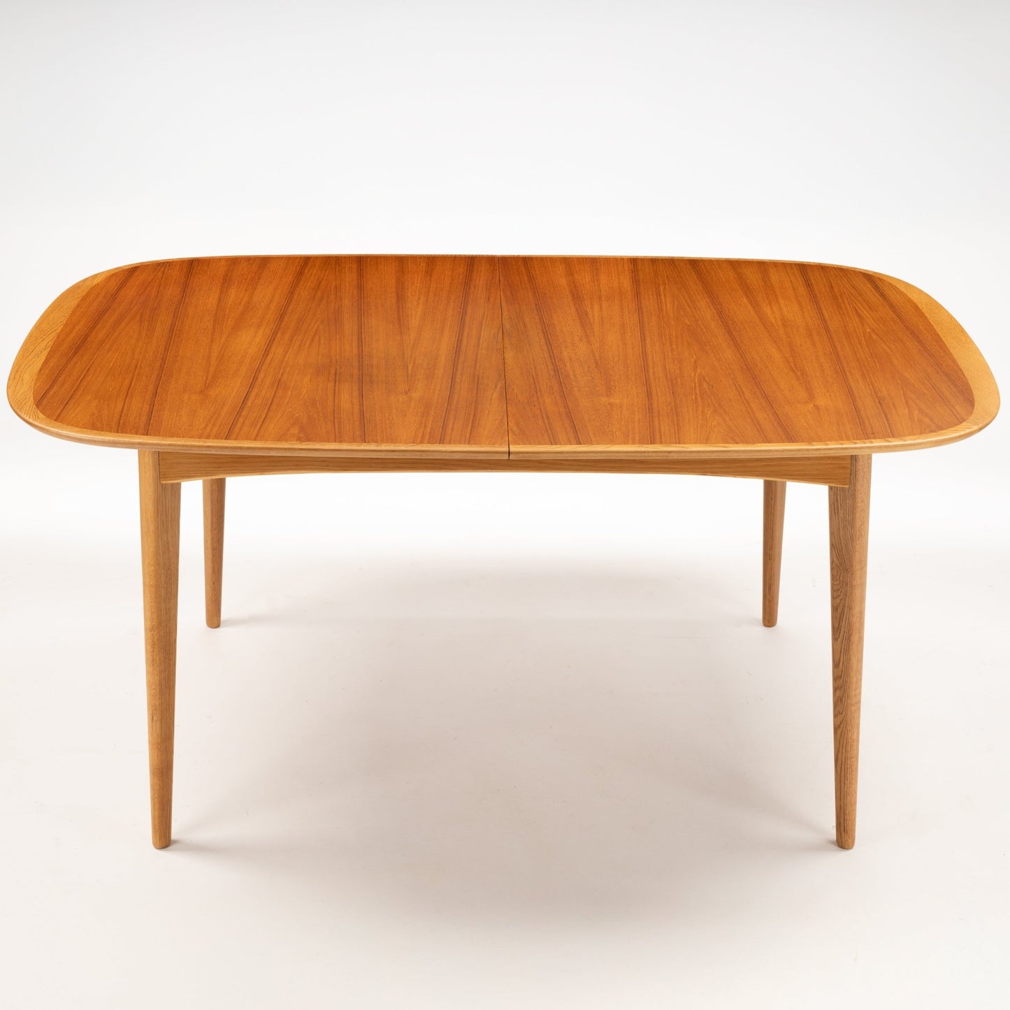 Danish Butterfly-Leaf Teak Dining Table with rounded rectangular top tapered legs and warm wood grain in mid century modern furniture style