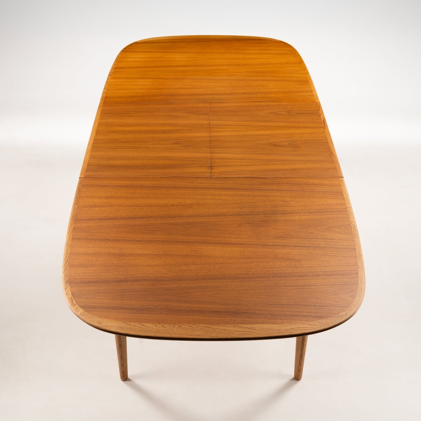 Danish Butterfly-Leaf Teak Dining Table viewed from above showing rounded rectangular top seamless teak grain and tapered legs in vintage Danish furniture style