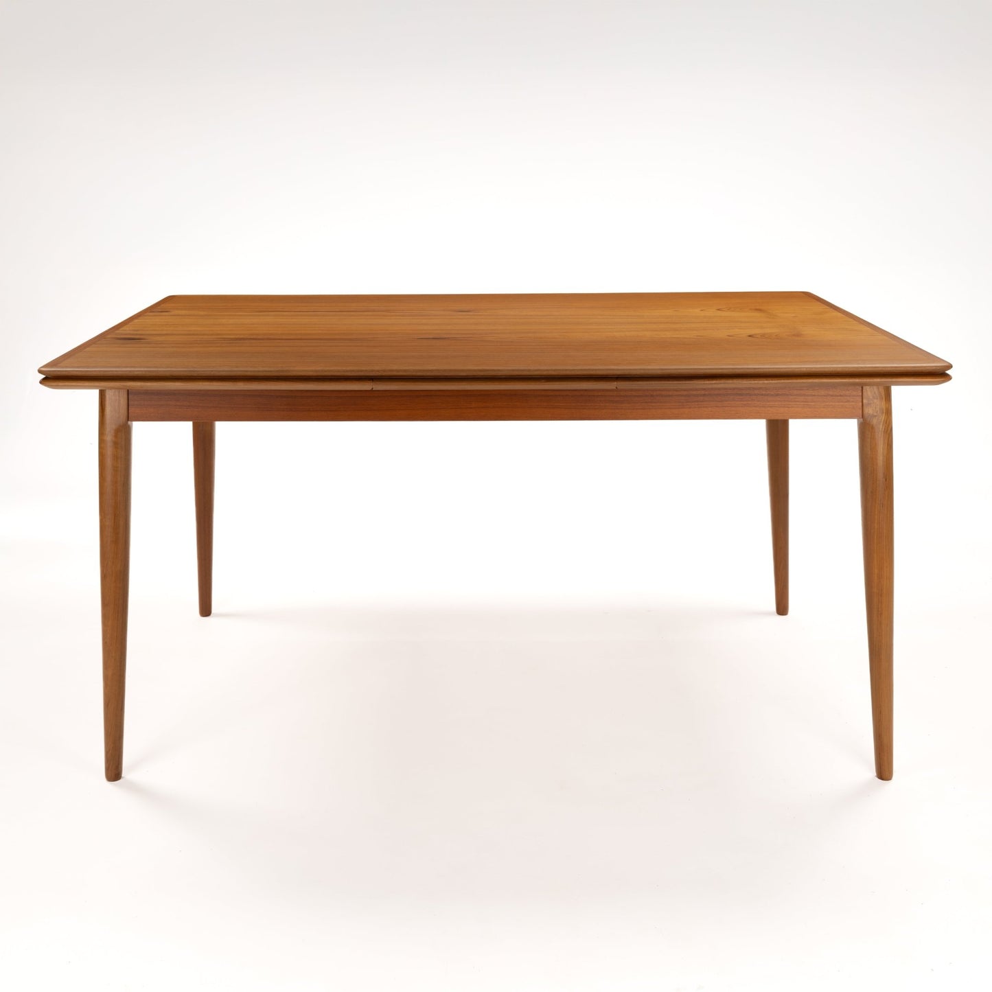Danish Draw-Leaf Dining Table in Teak with warm linear wood grain a slim rectangular top and four tapered legs in vintage Danish furniture style