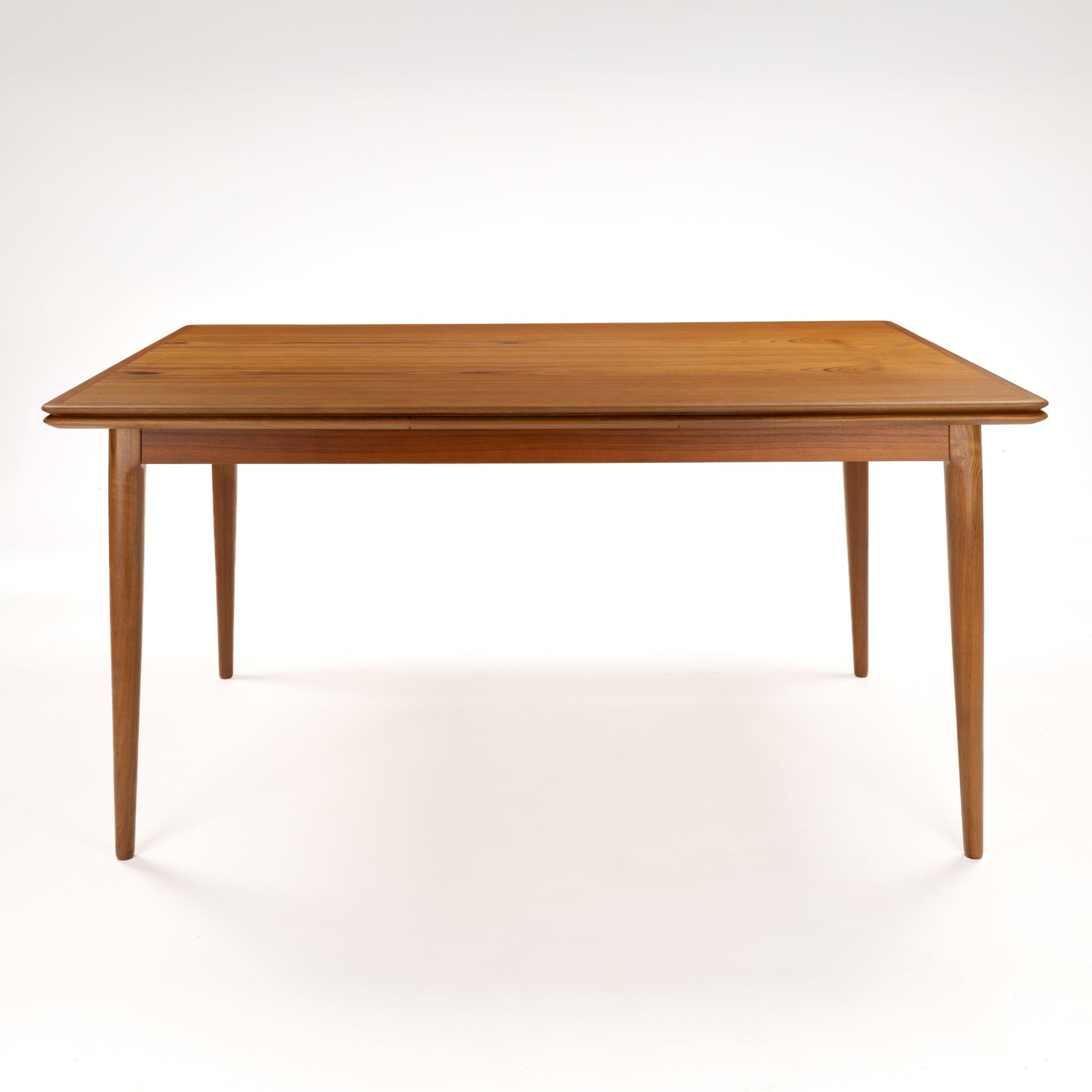 Danish Draw-Leaf Dining Table in Teak with warm linear wood grain a slim rectangular top and four tapered legs in vintage Danish furniture style