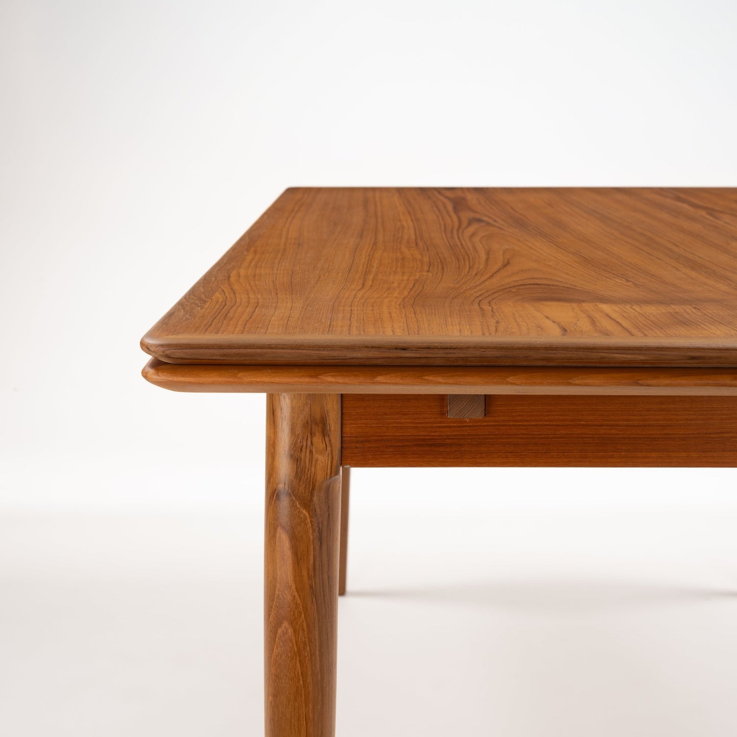 Danish Draw-Leaf Dining Table in Teak with rich natural wood grain rounded edges and a sturdy tapered leg showcasing vintage Danish furniture craftsmanship