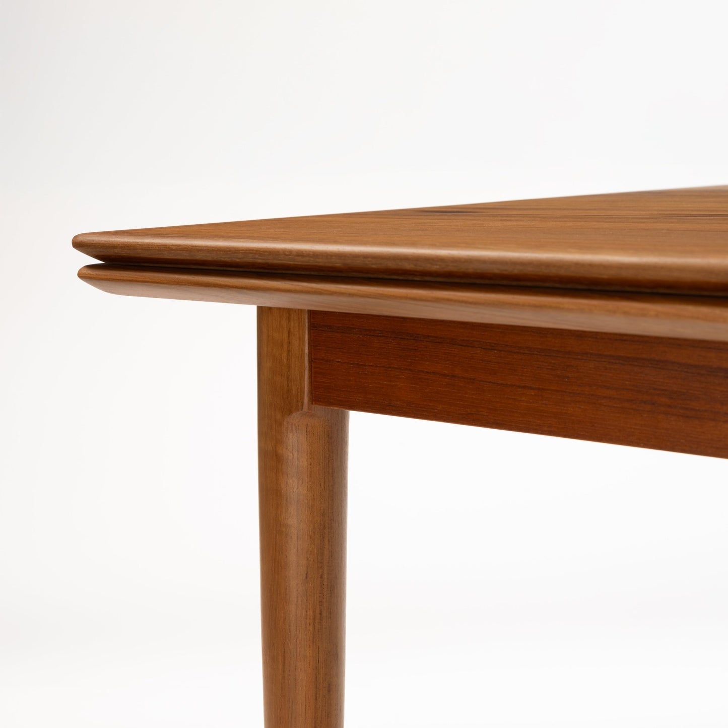Danish Draw-Leaf Dining Table in Teak with warm wood grain rounded table edge and tapered leg in vintage Danish furniture style