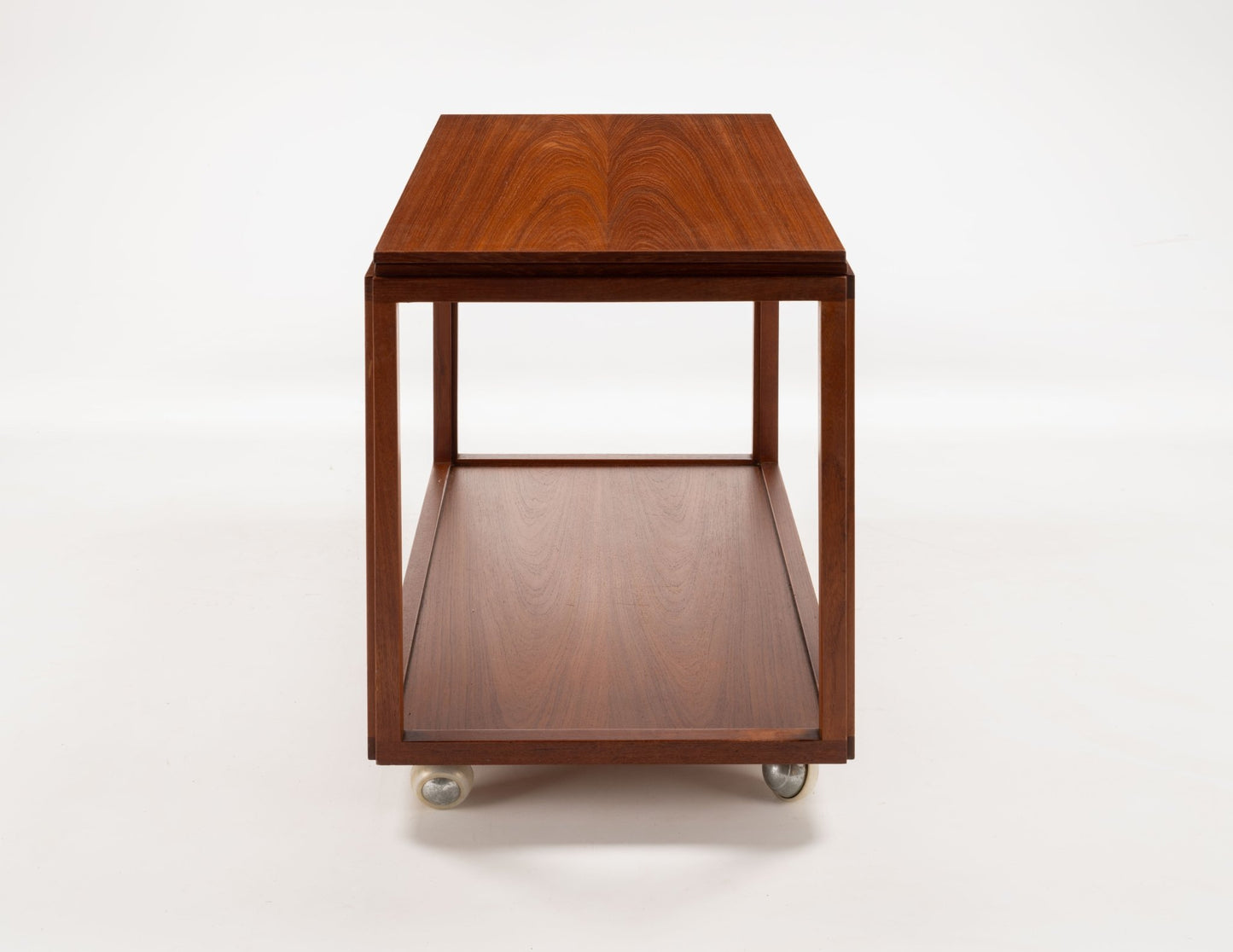 Danish teak expanding bar cart with minimalist design and wheels for mobility, showing front view of closed top surface