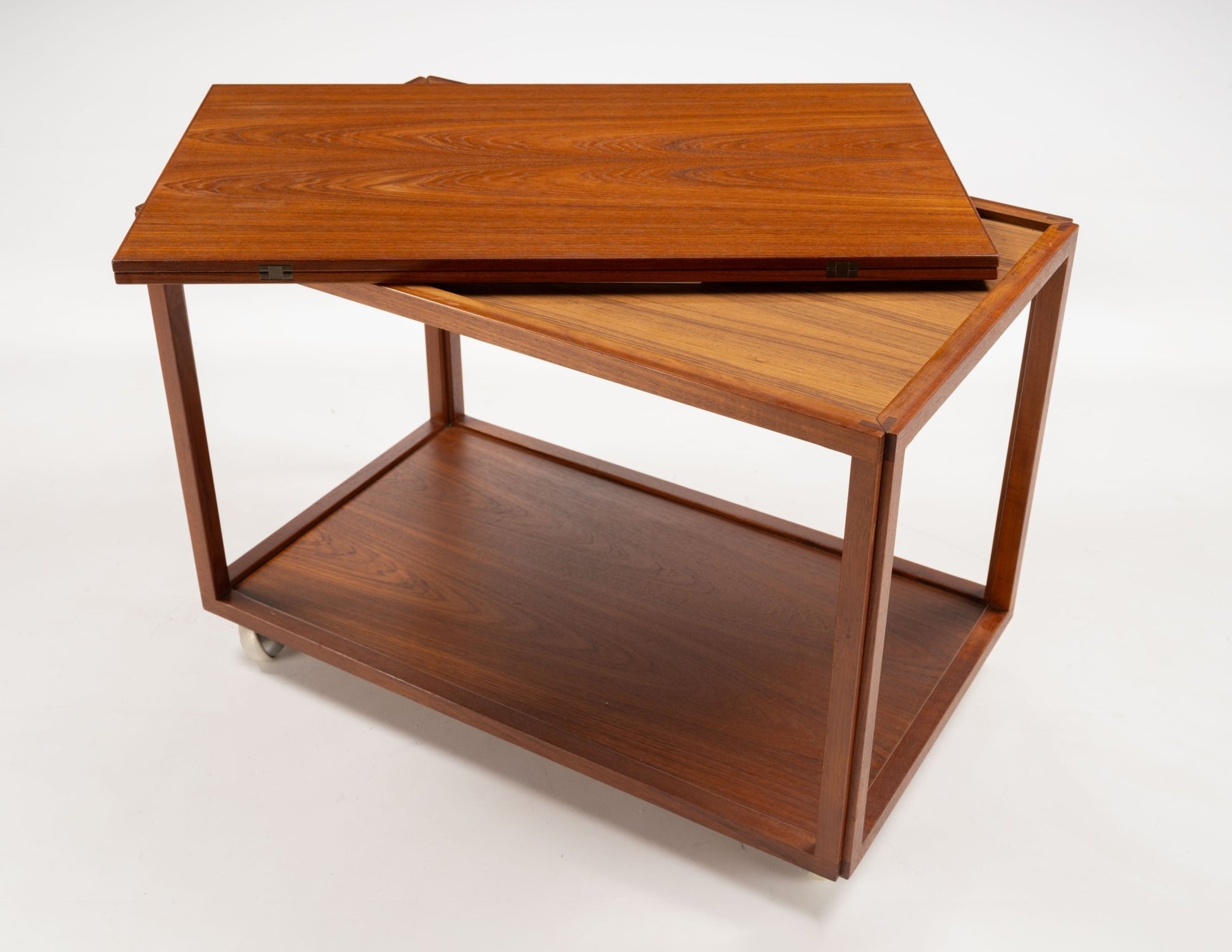 Danish teak expanding bar cart with a twist-open top revealing additional surface and caster wheels below