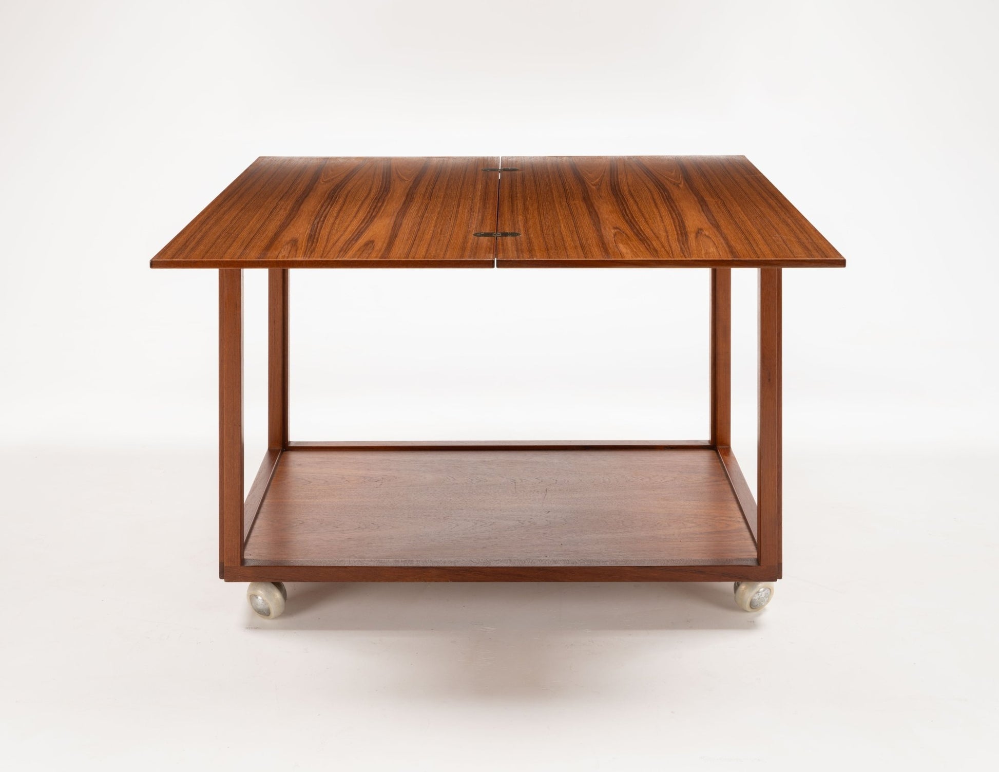 Danish teak expanding bar cart with a minimalist design and caster wheels for easy mobility.