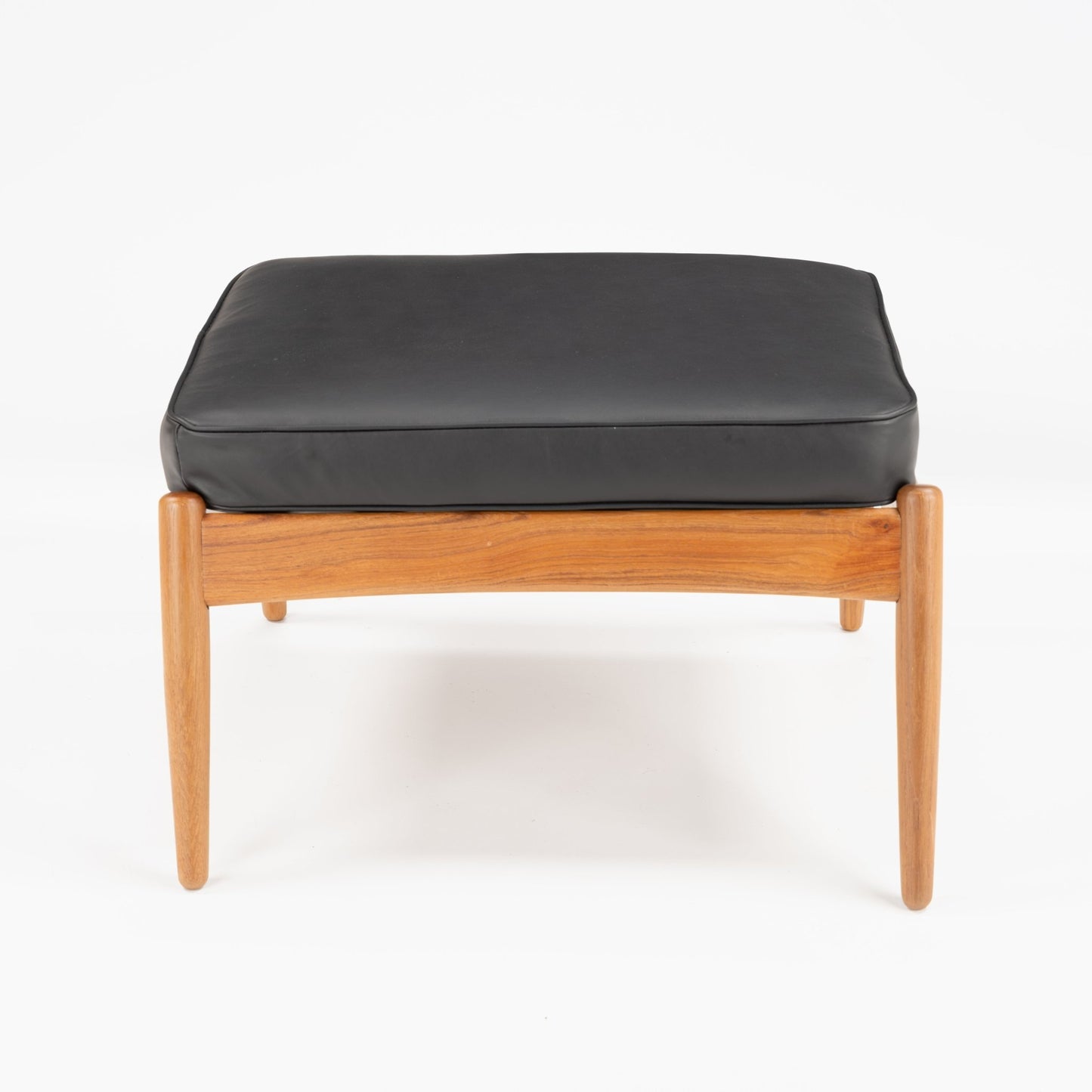 Danish Teak Ottoman with Black Leather featuring a sleek teak frame and smooth black leather cushion, showcasing elegant mid century modern seating design.