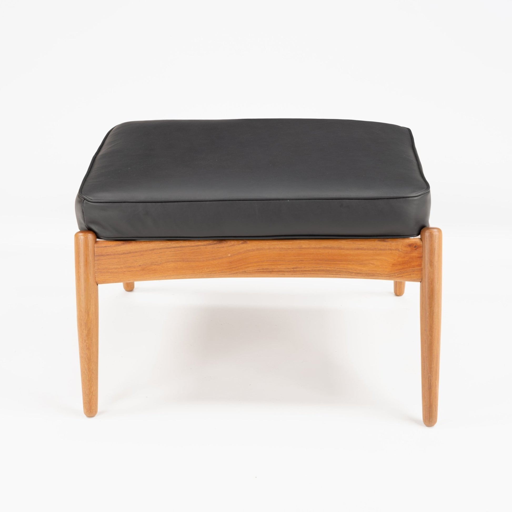 Danish Teak Ottoman with Black Leather featuring a sleek teak frame and smooth black leather cushion, showcasing elegant mid century modern seating design.