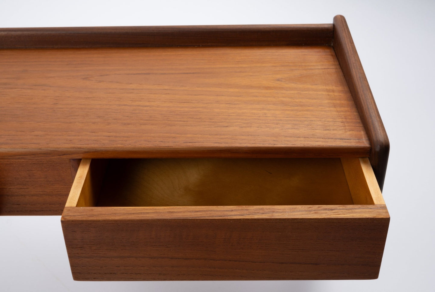 Danish modern teak shelf with open drawer, featuring clean lines and warm wood finish on white background.