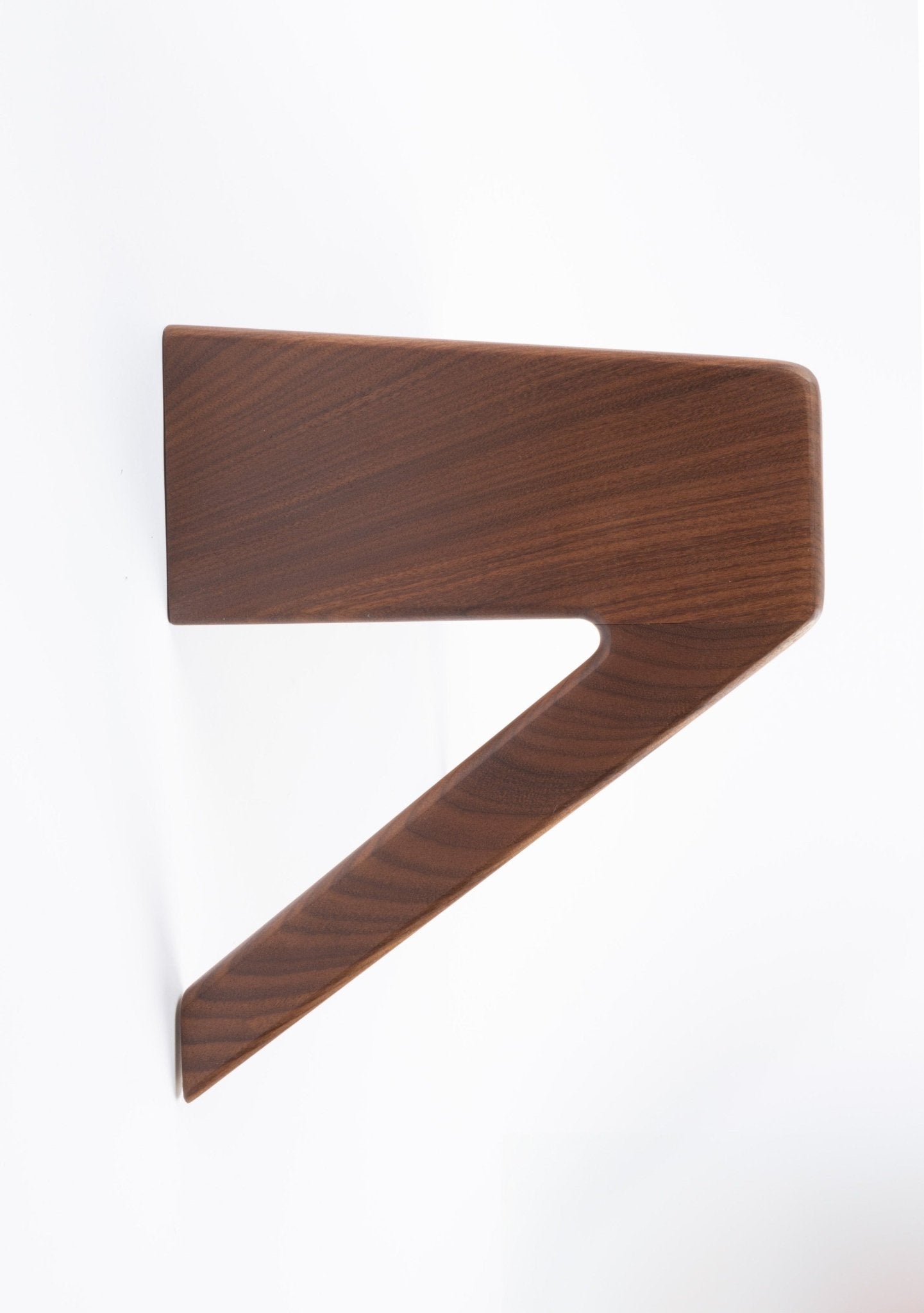 Danish modern teak wall shelf with integrated drawer, featuring sleek angled design and smooth wood grain finish.