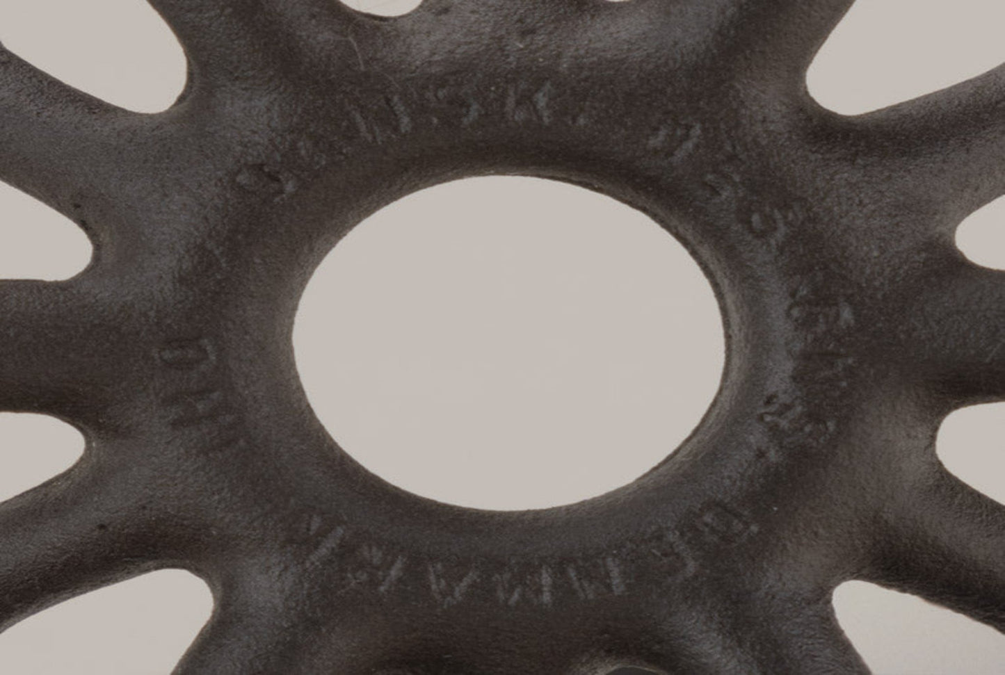 Close-up of black Dansk cast iron spider candleholder with Jens Quistgaard Denmark maker's mark on textured surface