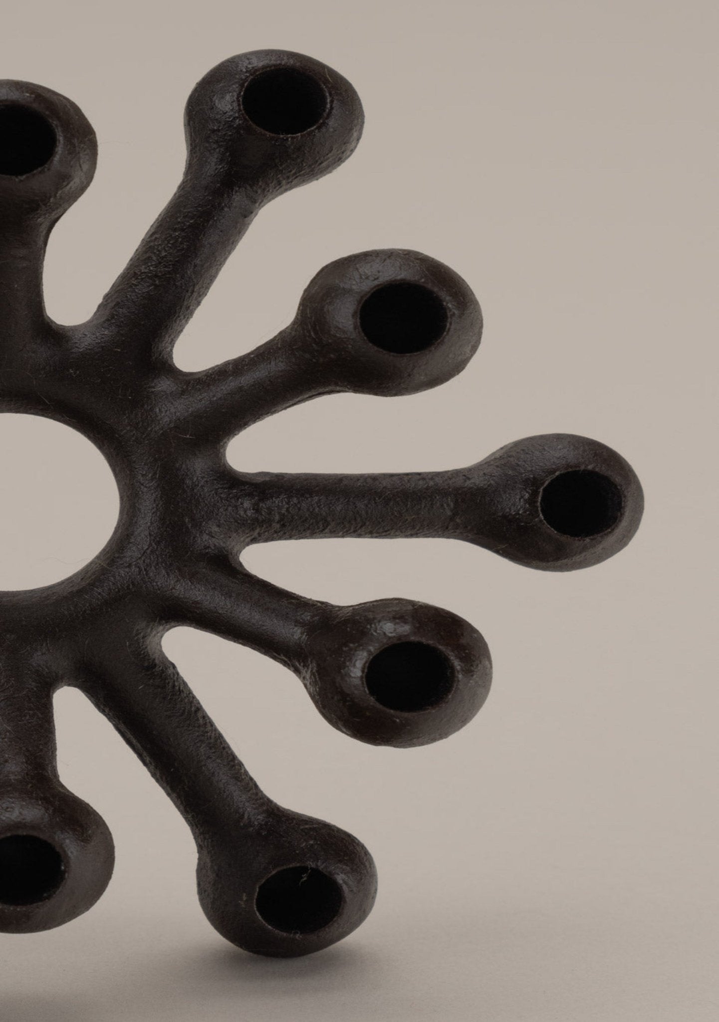 Close-up of black Dansk cast iron Spider candleholder designed by Jens Quistgaard with multiple rounded arms for candles