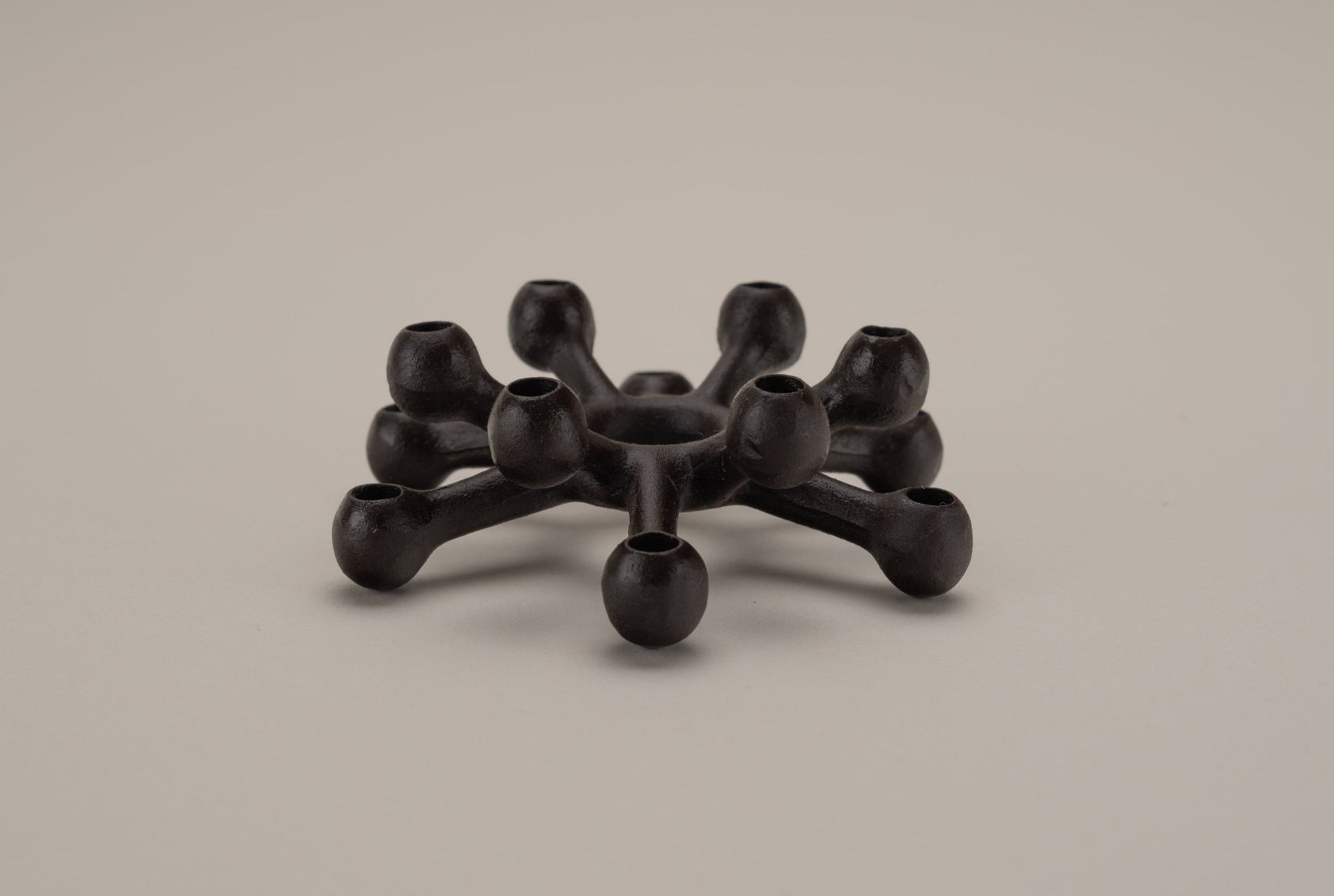 Dansk cast iron "Spider" candleholder designed by Jens Quistgaard with two-tier spider-like arms for thin candles.