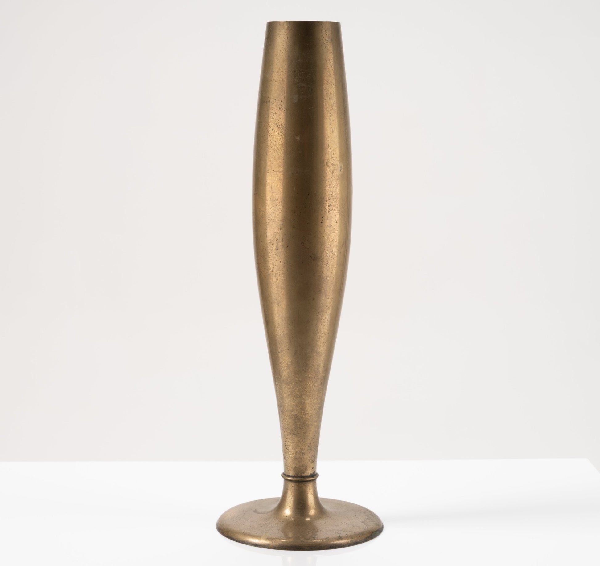 1930s Swedish Dirigold metal bud vase with warm patina and stable wide base on white background