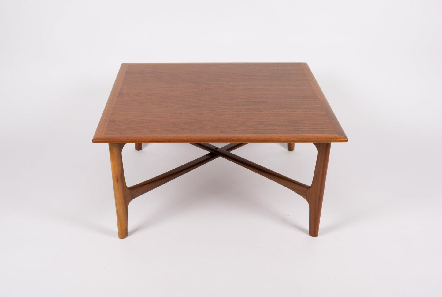 Square mid-century modern teak coffee table with book matched top and unique X-shaped base design.