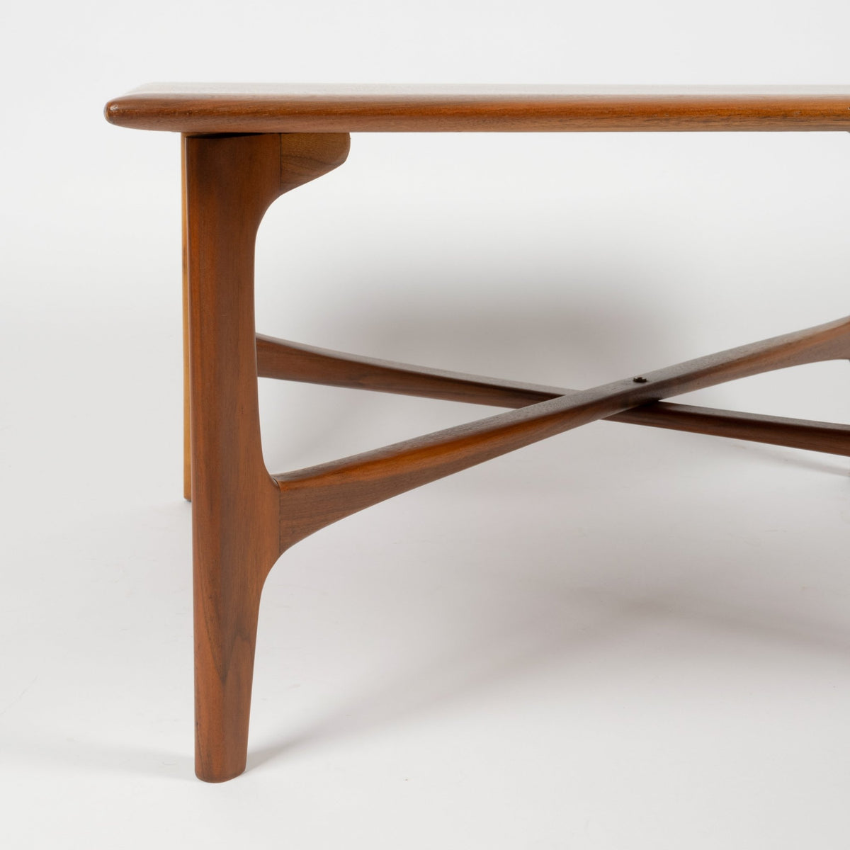 DUX Square Coffee Table by Ohlsson in warm walnut with rounded edge, curved leg and crossed supports against a white background for mid century modern furniture