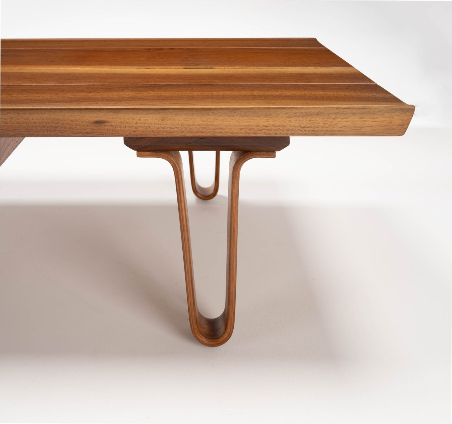 Close-up of Edward Wormley "Long John" solid walnut coffee table with bentwood hairpin legs and sculpted edges on the 84" top