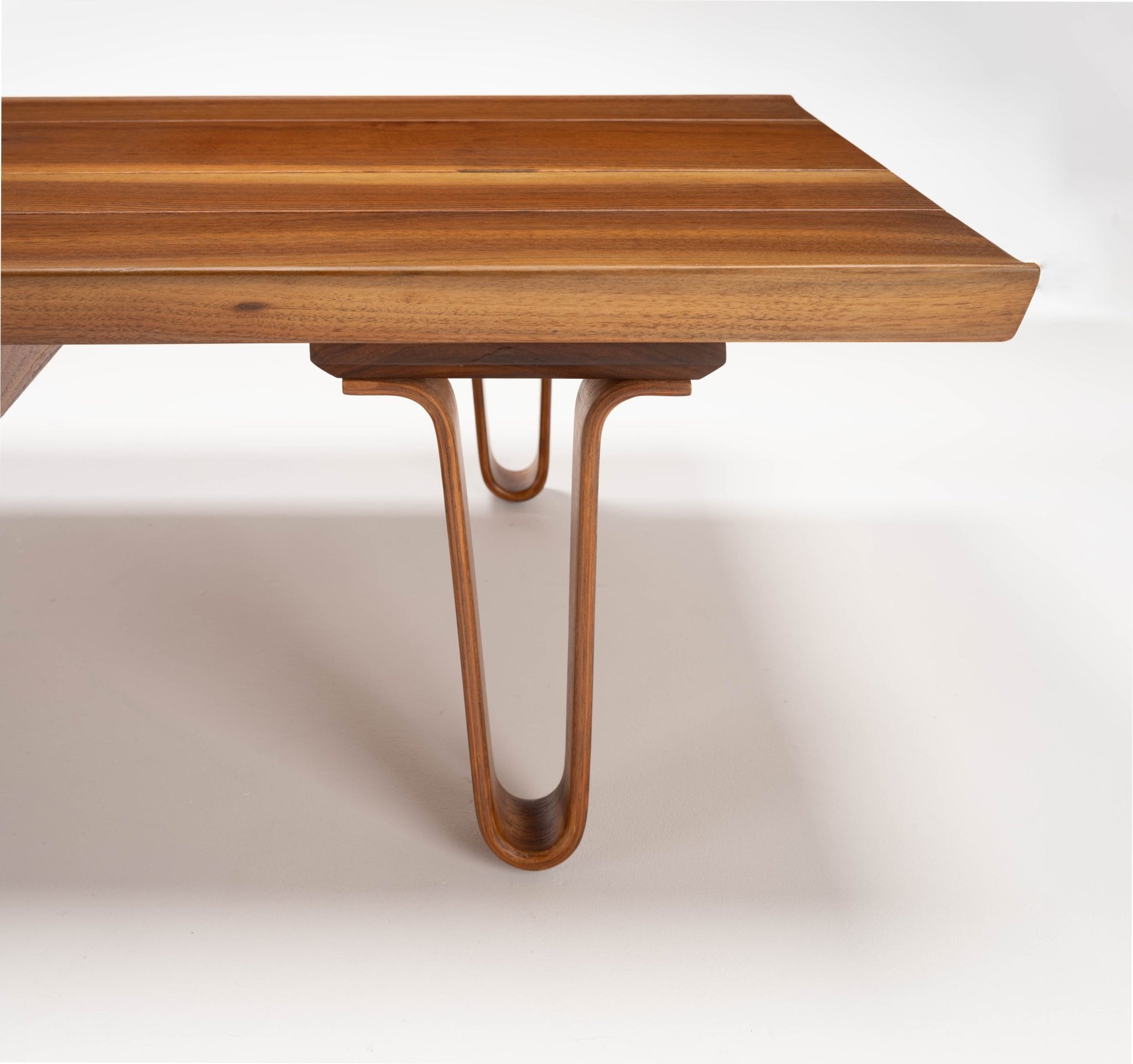 Close-up of Edward Wormley "Long John" solid walnut coffee table with bentwood hairpin legs and sculpted edges on the 84" top