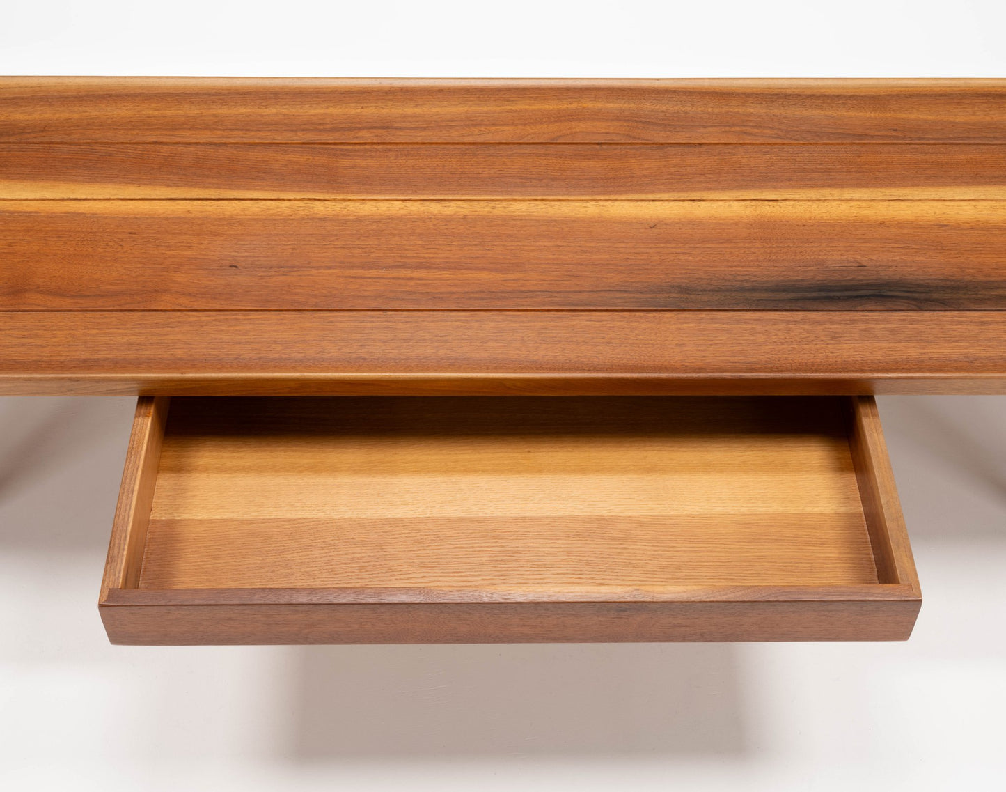 Close-up of Edward Wormley "Long John" walnut coffee table drawer with sculpted edges and bentwood hairpin legs visible