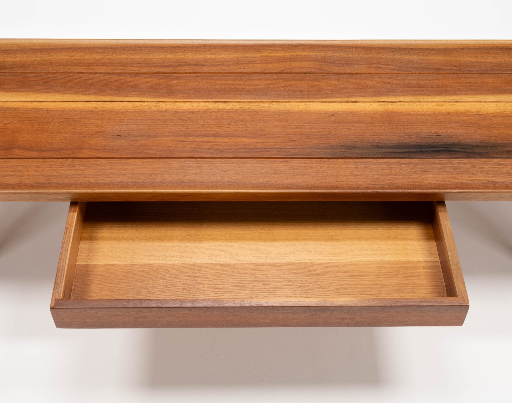 Close-up of Edward Wormley "Long John" walnut coffee table drawer with sculpted edges and bentwood hairpin legs visible
