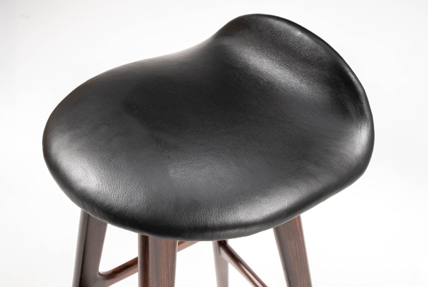 Mid-century modern Erik Buch bar stool with black leather contoured seat and rosewood frame on white background.