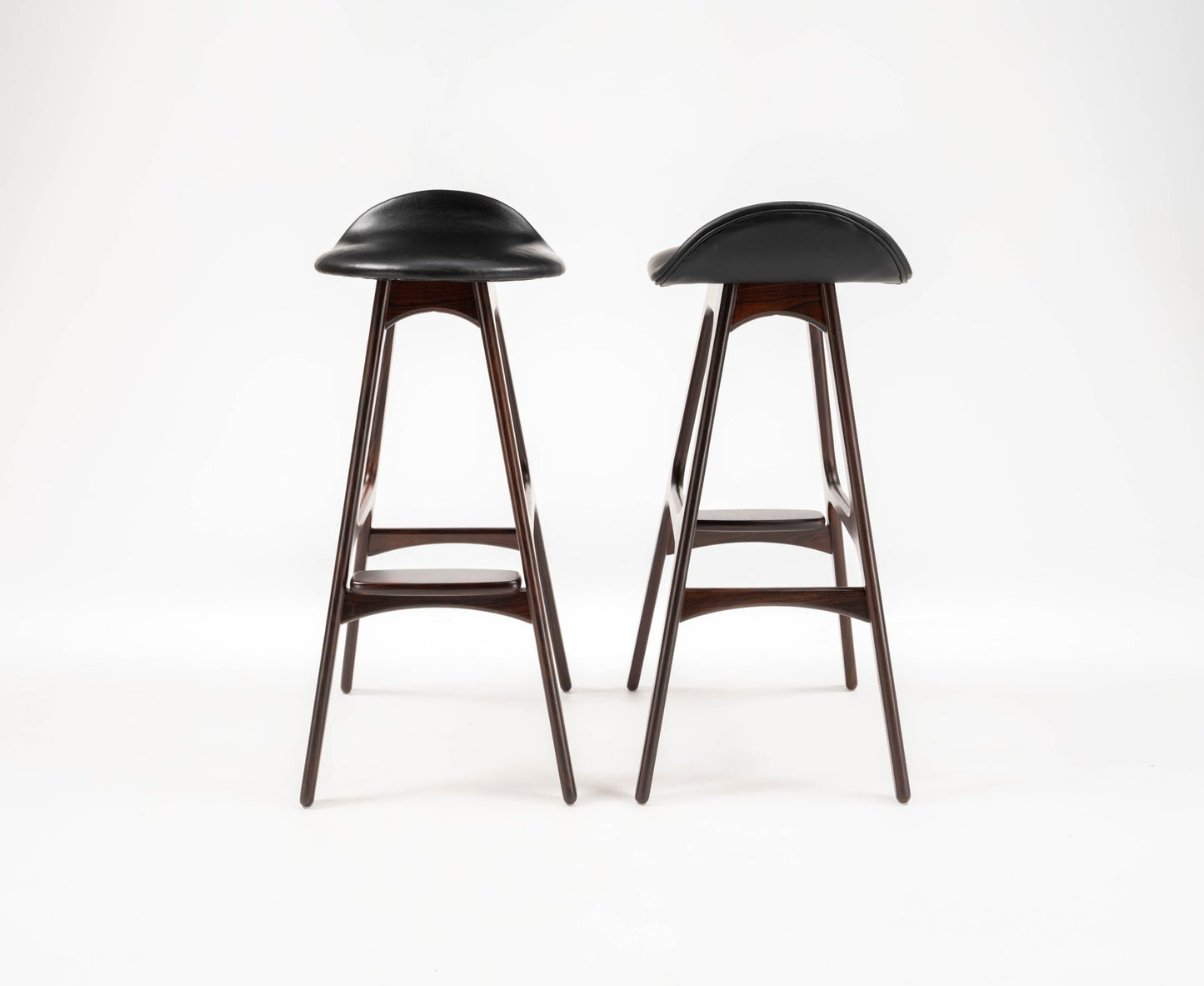 Pair of 1960s Danish Erik Buch bar stools with black leather contoured seats and rosewood frames on white background