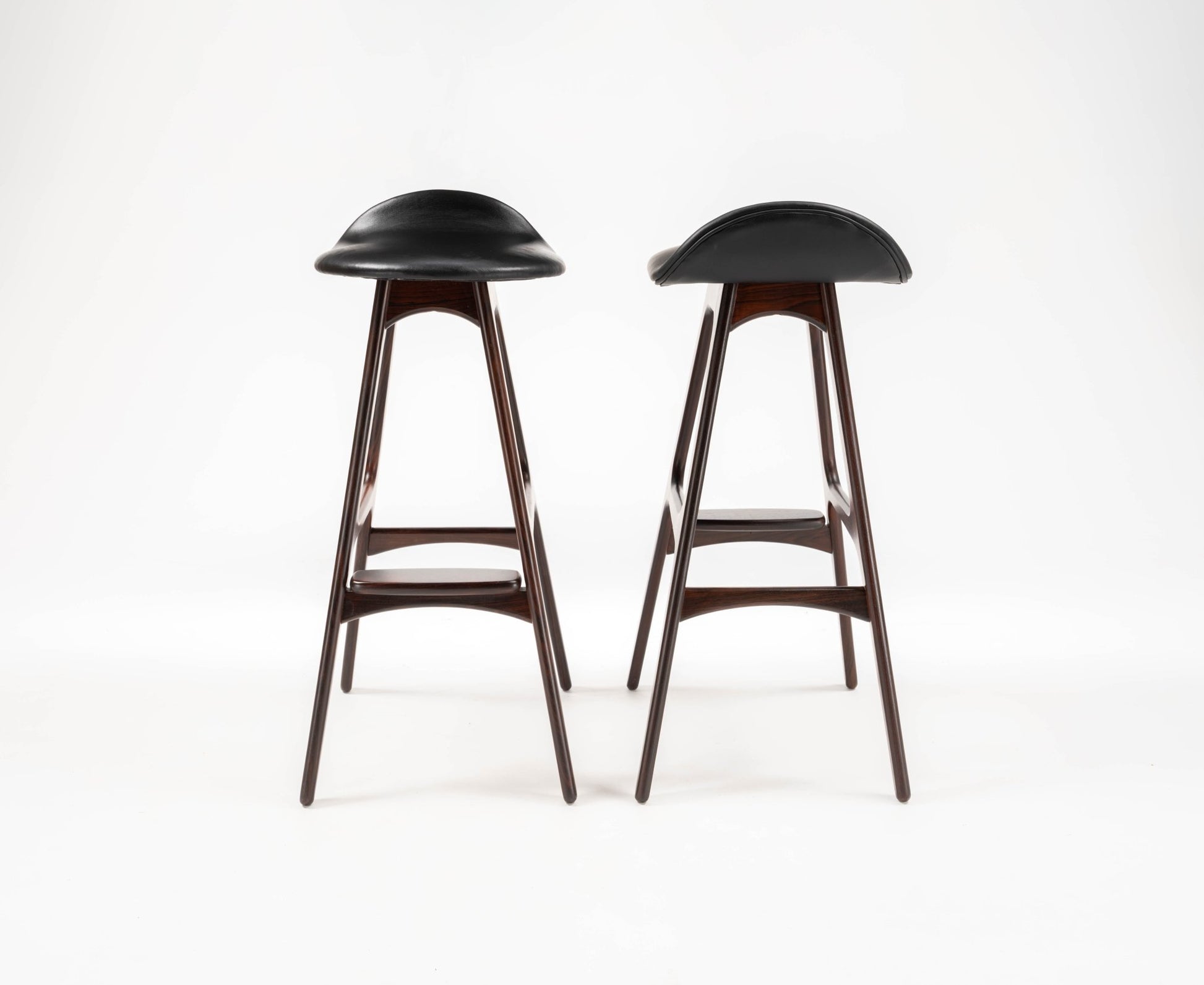 Pair of 1960s Danish Erik Buch bar stools with black leather contoured seats and rosewood frames on white background