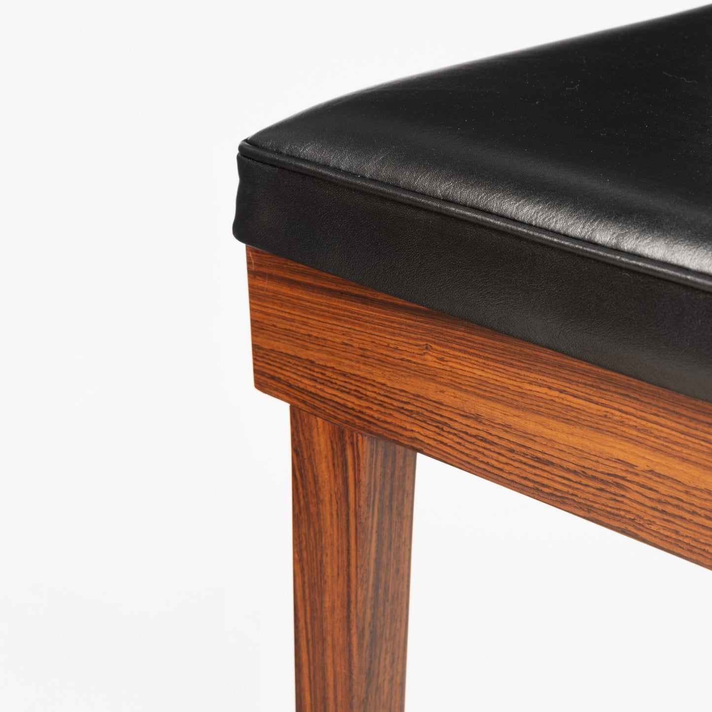 Erik Buck Pair of Rosewood Stools highlighting a smooth black leather seat cushion set on a richly grained rosewood frame leg, exemplifying vintage Danish mid century modern seating craftsmanship.