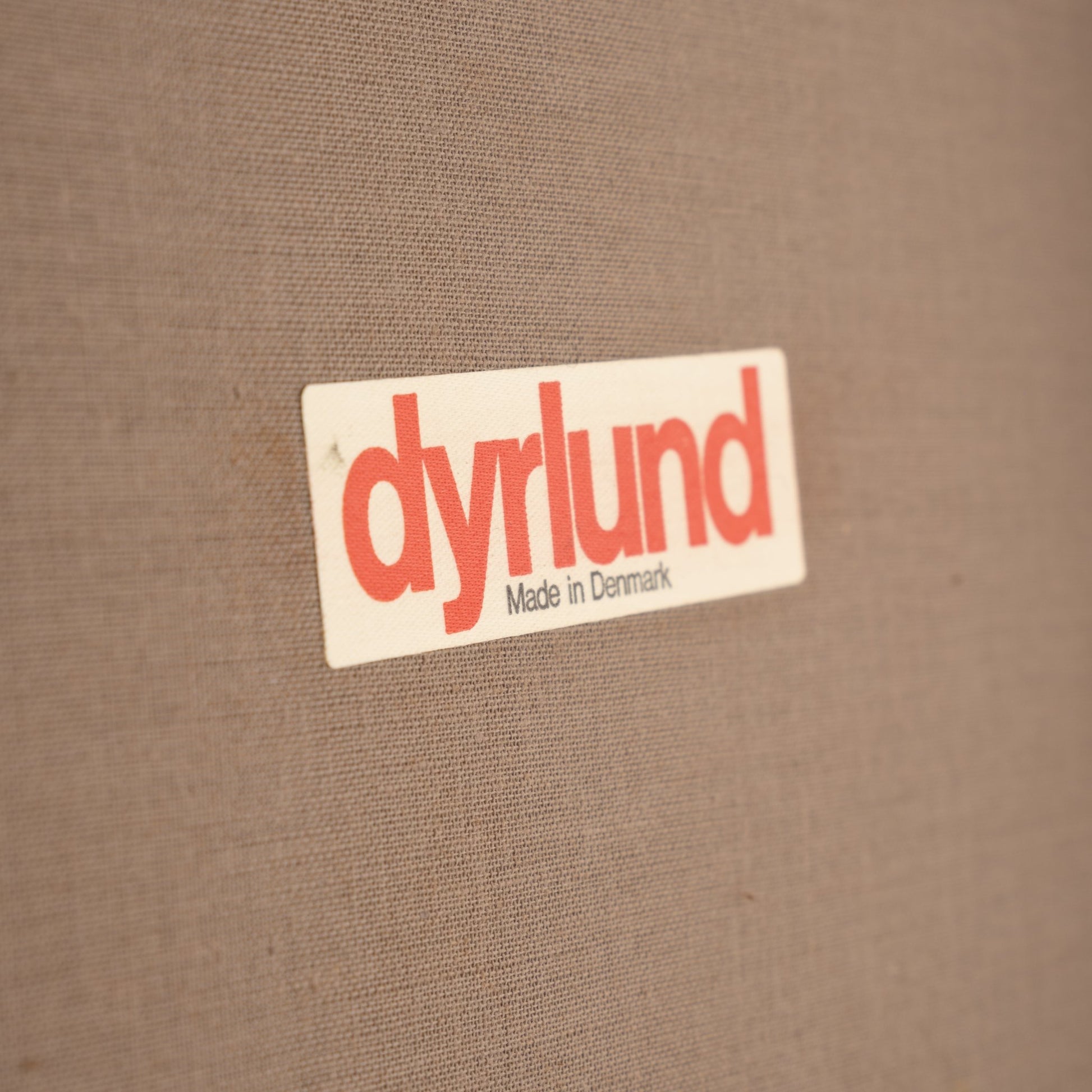 Erik Buck Pair of Rosewood Stools featuring a close-up of a woven fabric label with "dyrlund Made in Denmark" printed in red and black, highlighting authentic vintage Danish craftsmanship.