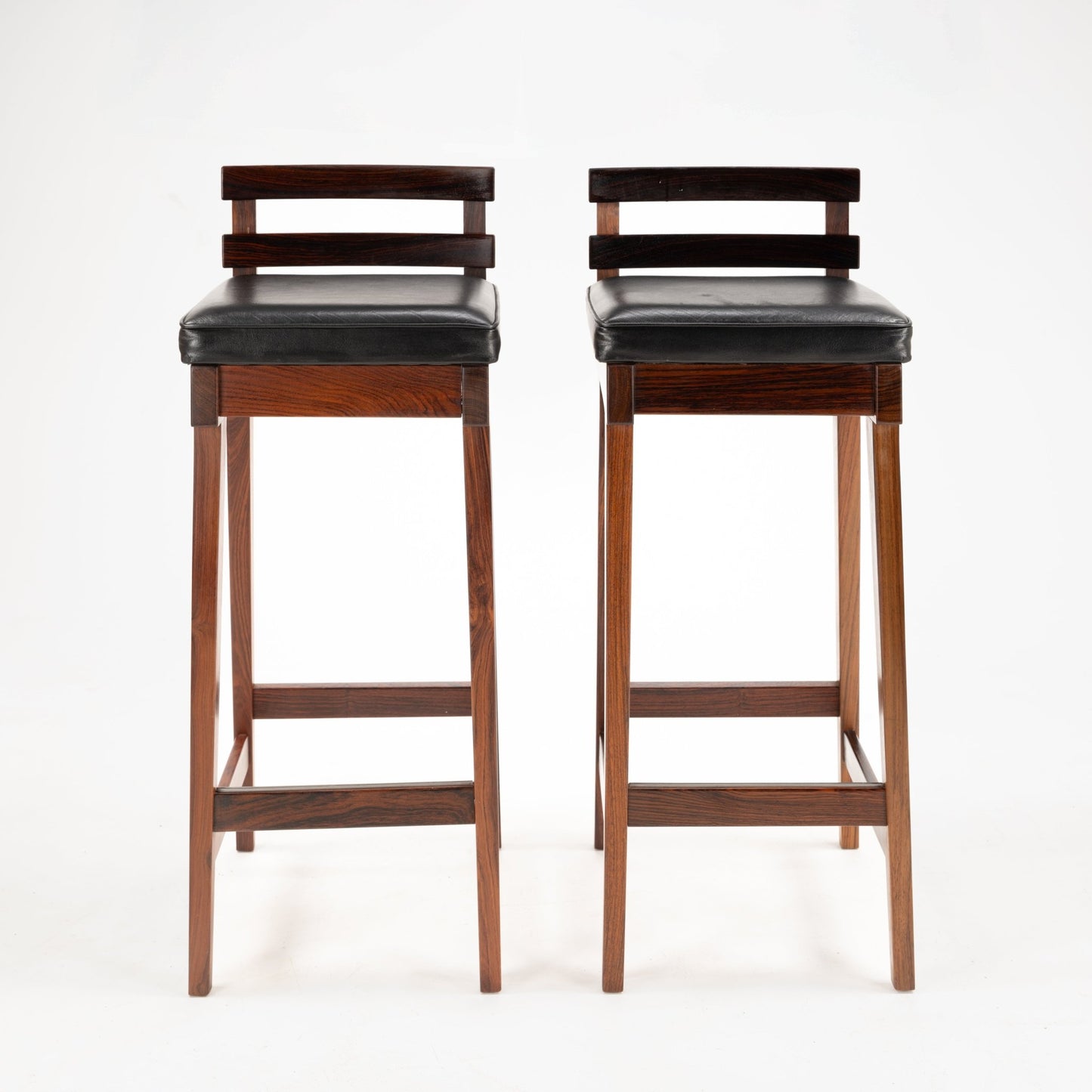 Erik Buck Pair of Rosewood Stools with slender rosewood frames, horizontal back slats, and black leather padded seats offering classic mid century modern seating appeal.
