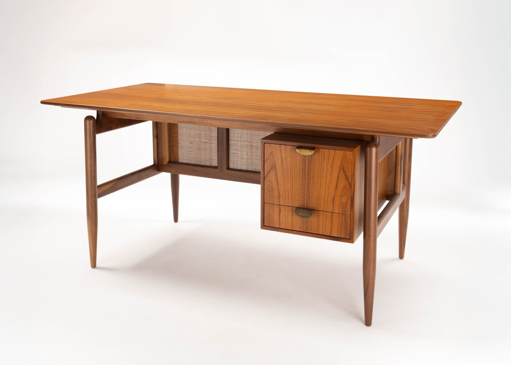 Mid-century modern walnut executive desk with cane paneling, tapered legs, and two drawers on one side