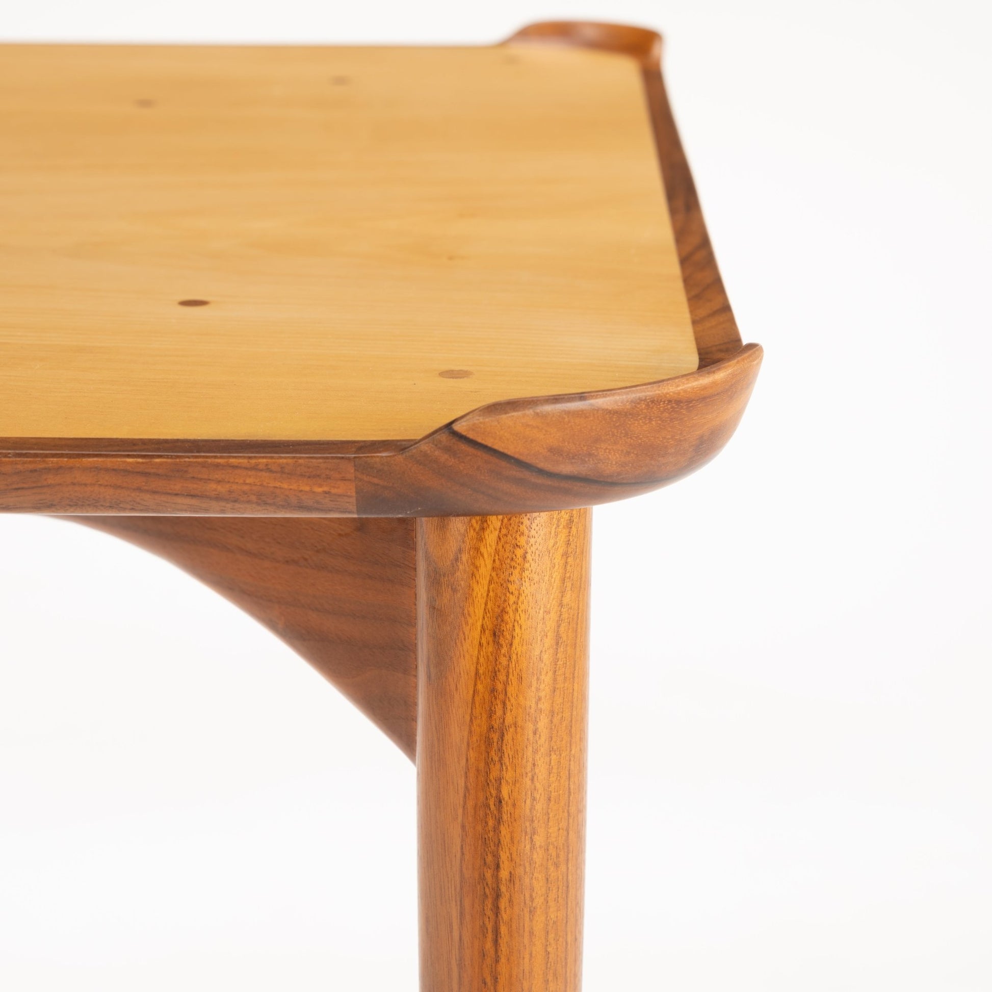 Finn Juhl Walnut Card Table for Baker displaying a sculpted walnut rim with gracefully curved corners and a smooth light wood surface, supported by a sturdy vintage Danish mid century modern leg structure.