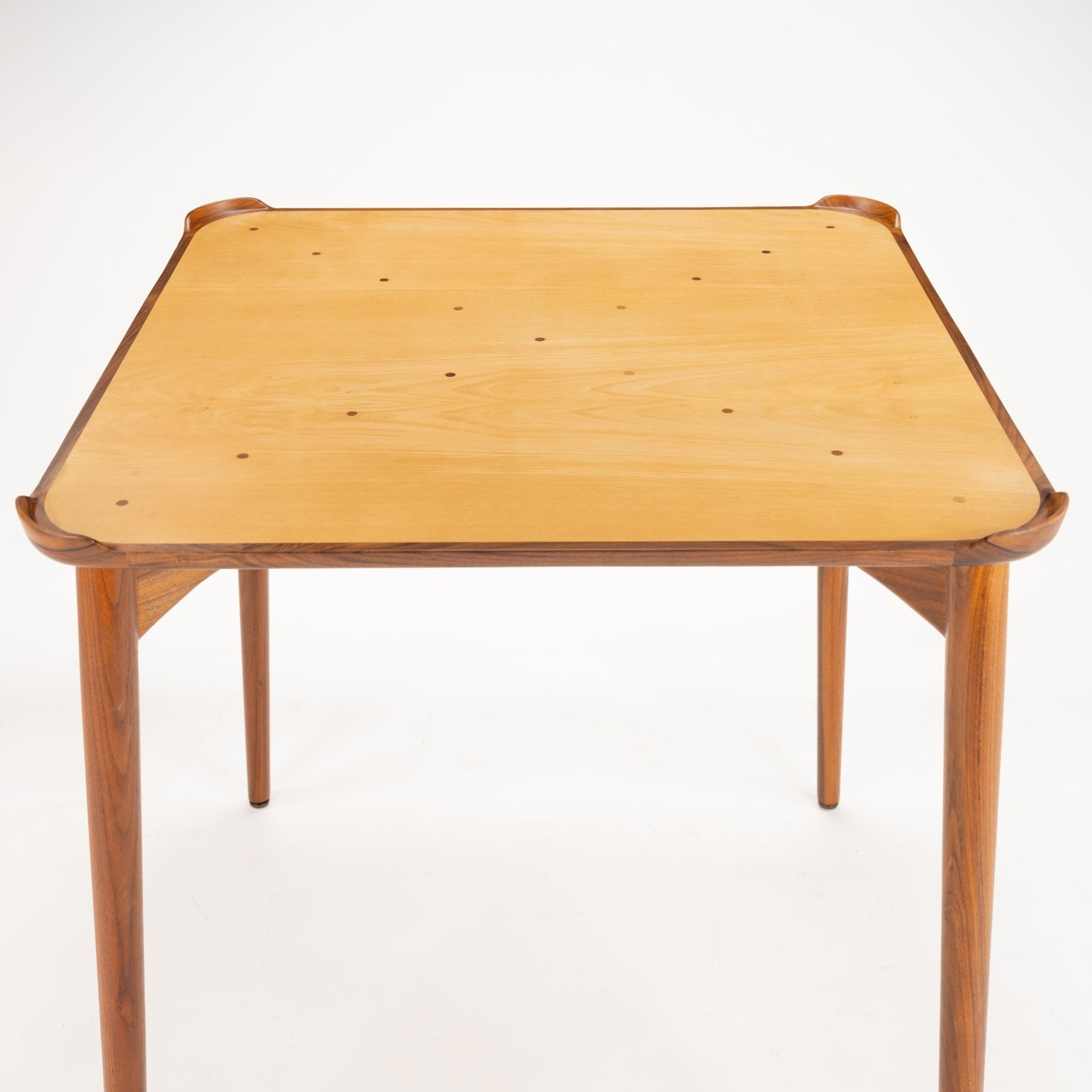 Finn Juhl Walnut Card Table for Baker highlighting a smooth, natural wood tabletop with rounded edges and sculpted walnut frame supported by slender, tapered legs, embodying vintage Danish mid century modern design.
