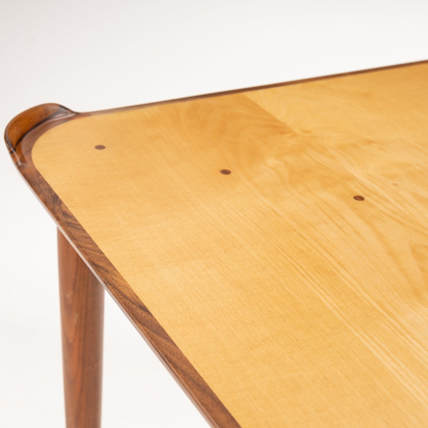 Finn Juhl Walnut Card Table for Baker highlighting a light wood tabletop with subtle grain patterns and rounded corners, framed by rich walnut edges and supported by slender tapered legs in vintage Danish mid century modern style.