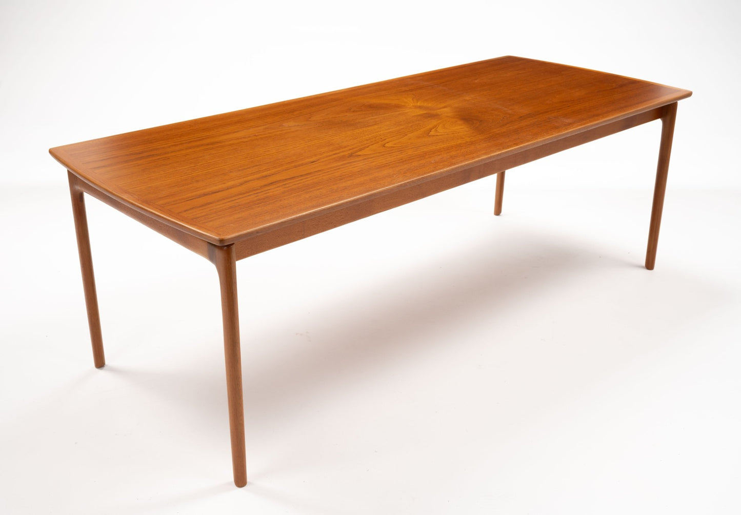 Mid-century modern teak coffee table by Ole Wanscher with floating top design and slender tapered legs on white background