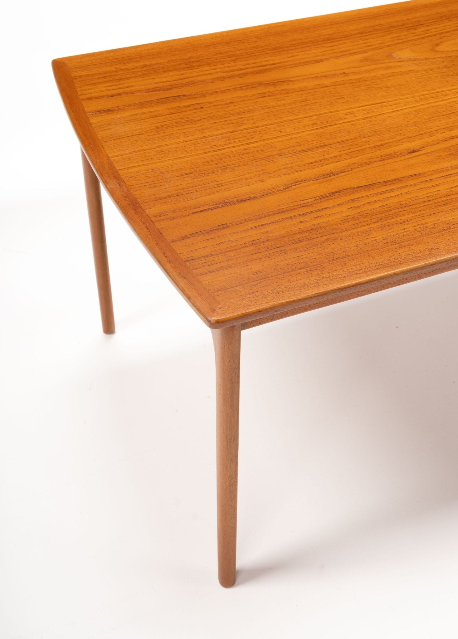 Mid-century modern teak floating top coffee table with tapered legs and smooth rectangular surface on white background