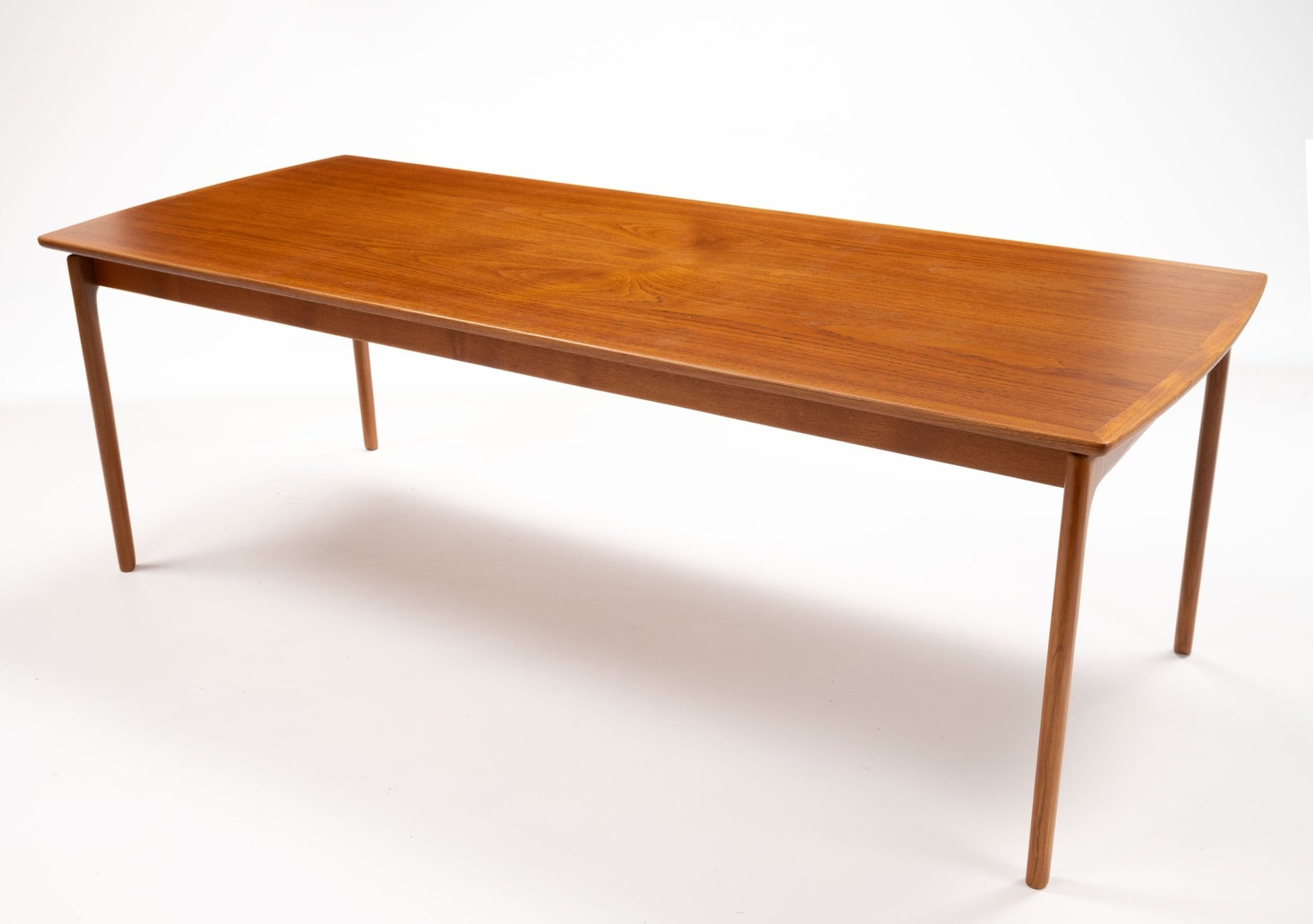Mid-century modern teak coffee table by Ole Wanscher with floating top design and slender tapered legs on white background