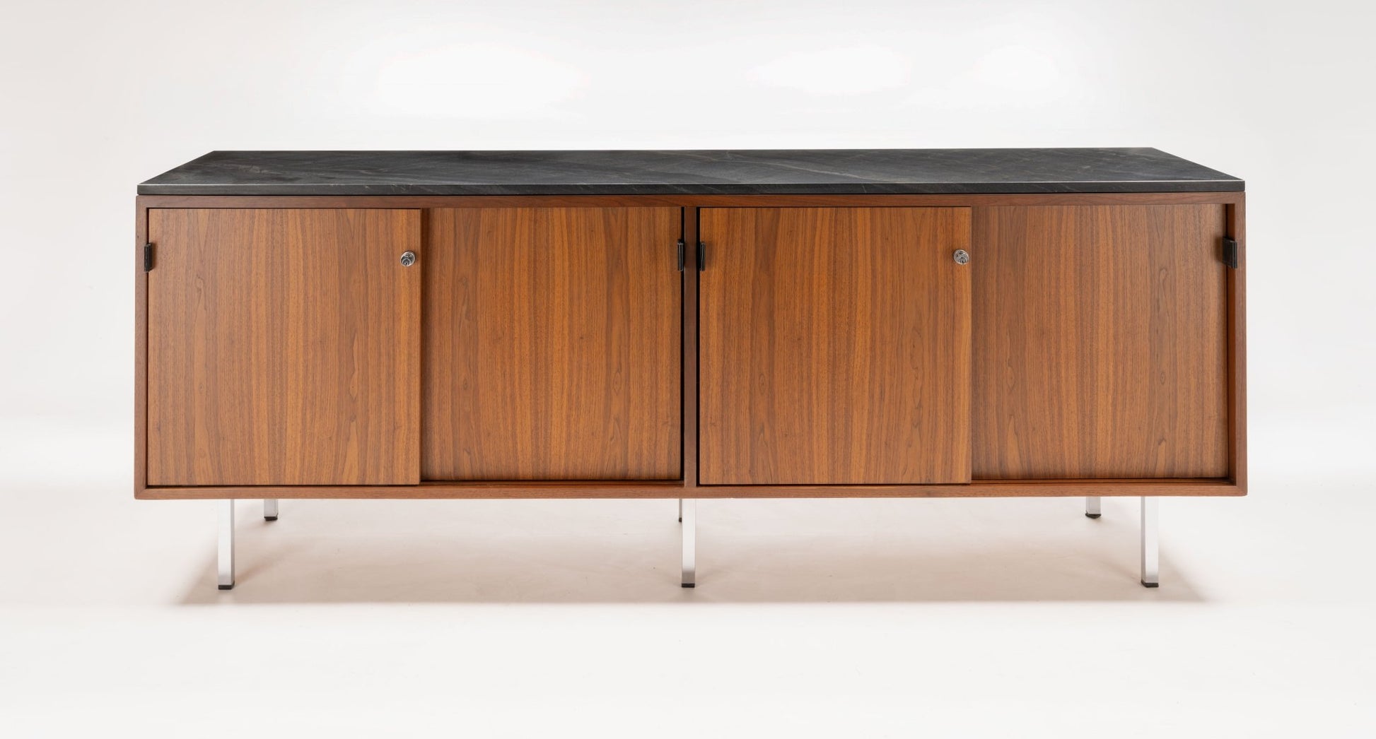 Mid-century walnut credenza with black marble top, four sliding doors with leather pulls, and polished metal legs.