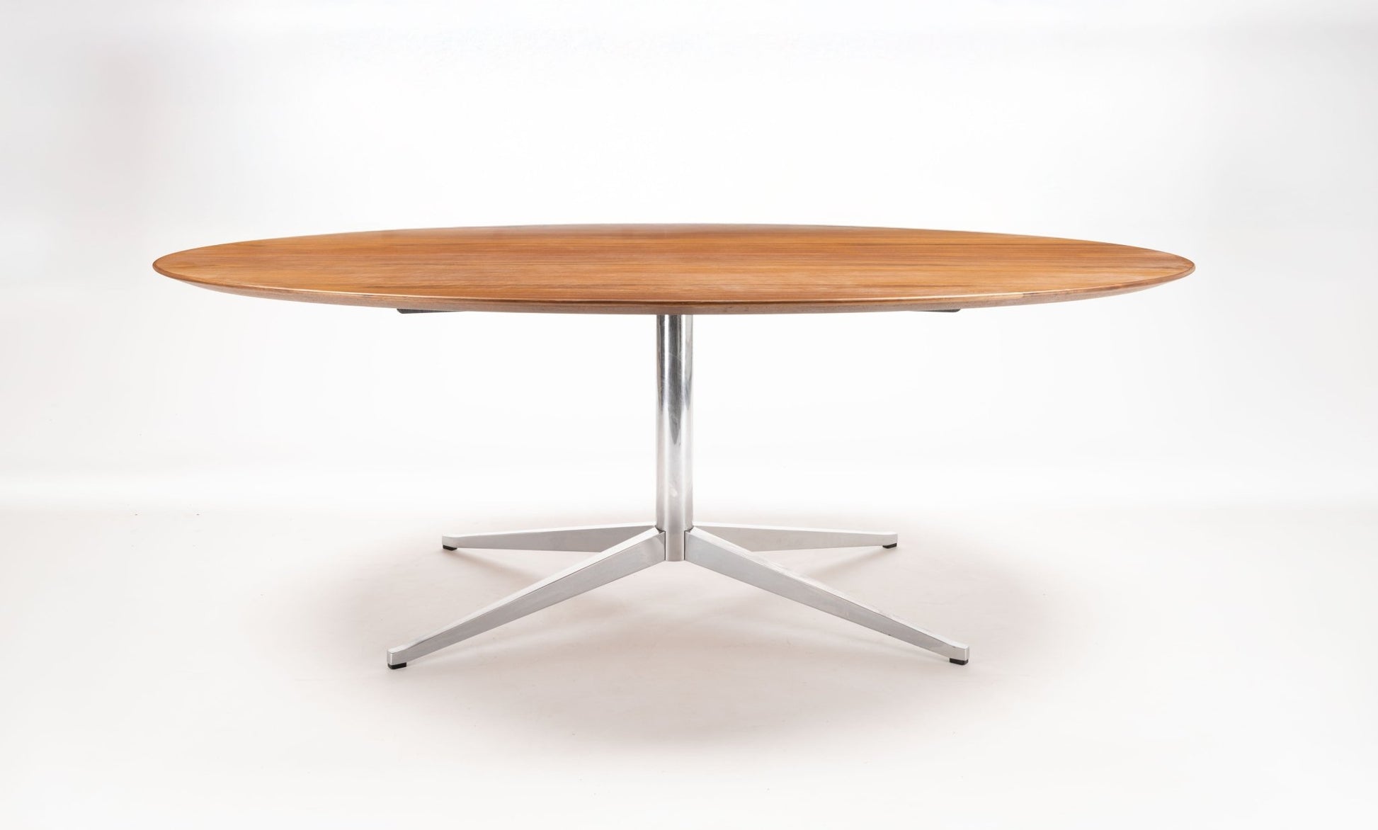 Mid-century modern oval walnut dining table with polished chrome four-star base by Florence Knoll, 1961 design.