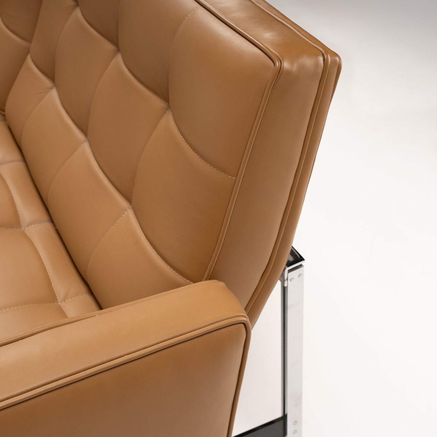 Florence Knoll 'Relaxed' Settee in Leather close up showing caramel brown tufted upholstery structured arm and polished chrome frame in mid century modern furniture style