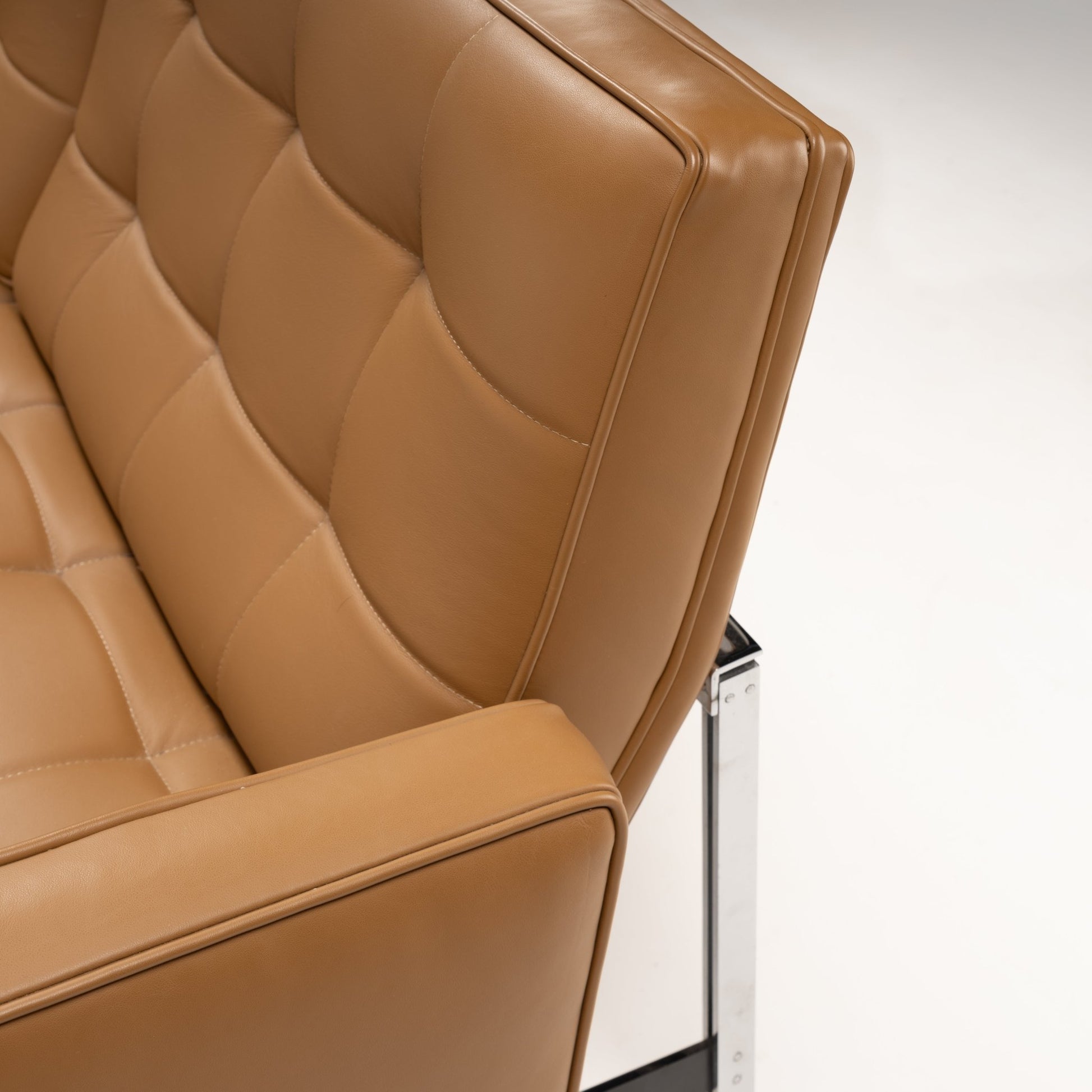 Florence Knoll 'Relaxed' Settee in Leather close up showing caramel brown tufted upholstery structured arm and polished chrome frame in mid century modern furniture style