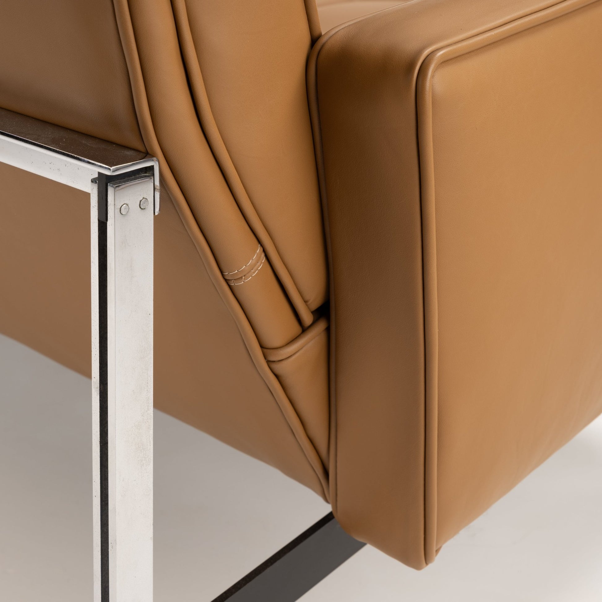 Florence Knoll 'Relaxed' Settee in Leather close up showing caramel brown leather seams structured arm and polished metal frame in mid century modern furniture style