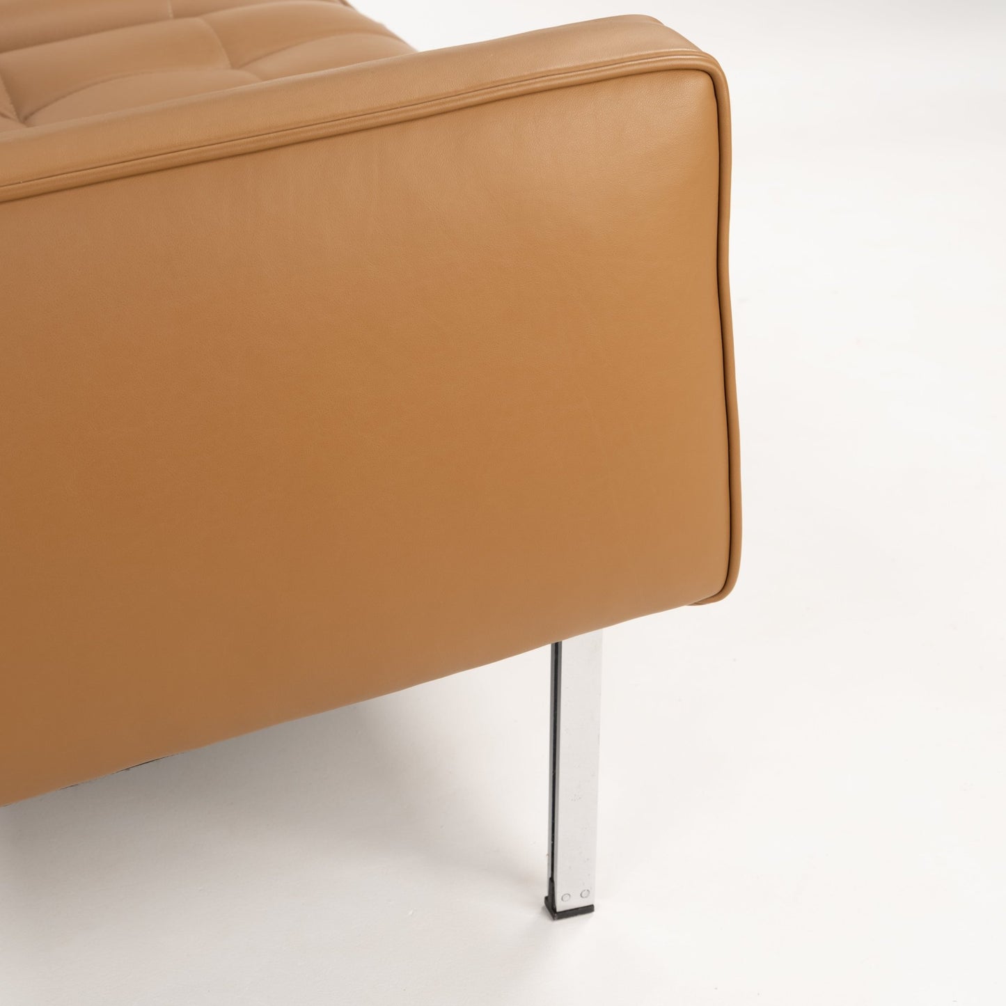 Florence Knoll 'Relaxed' Settee in Leather showing caramel brown upholstery with stitched cushion detailing and a slender polished metal leg in mid century modern furniture style