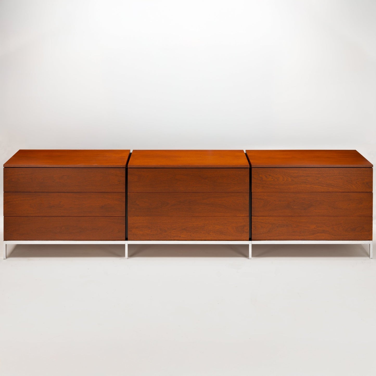 Florence Knoll Walnut Chest of Drawers with three cabinet sections rich walnut grain and slim white metal legs in mid century modern furniture style