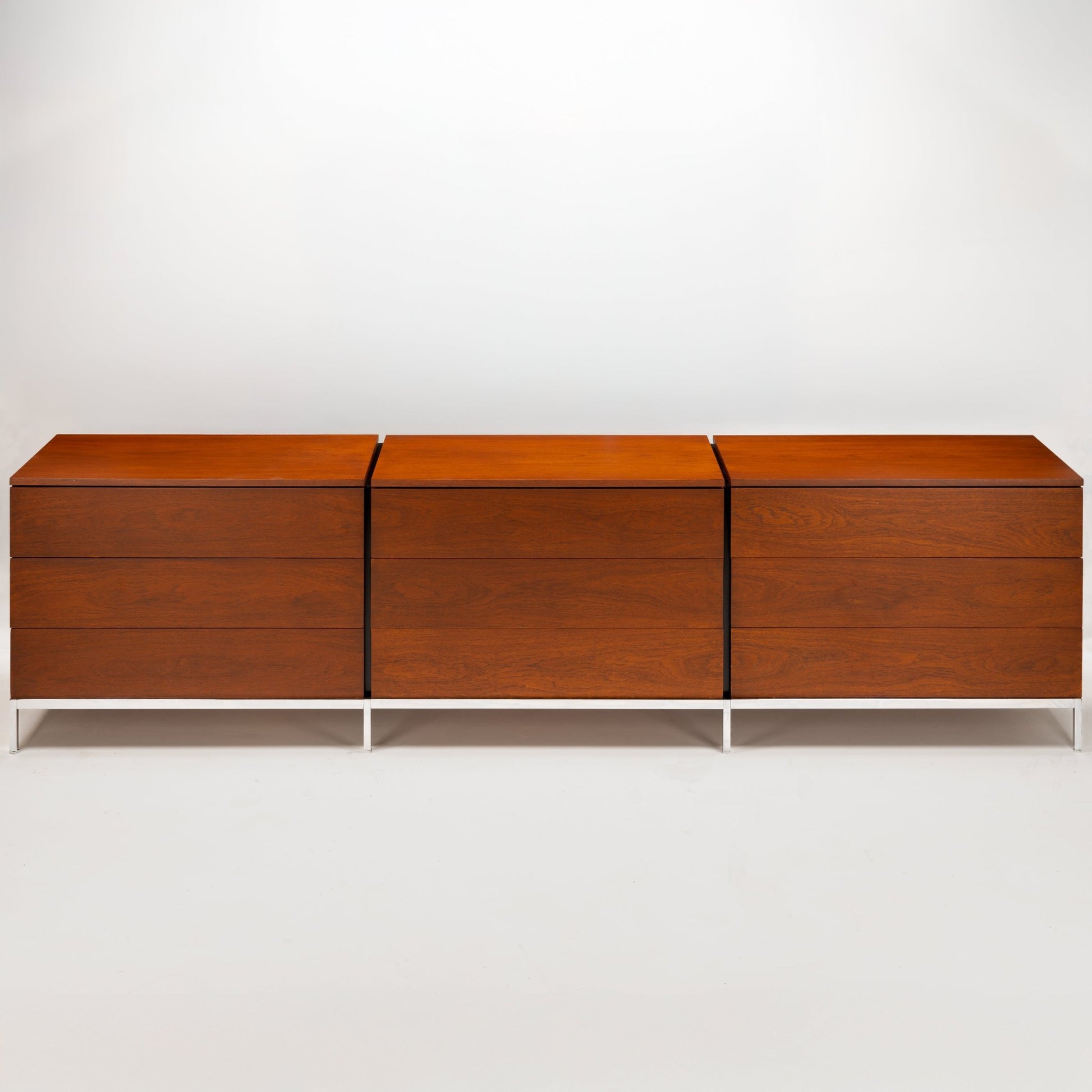 Florence Knoll Walnut Chest of Drawers with three cabinet sections rich walnut grain and slim white metal legs in mid century modern furniture style