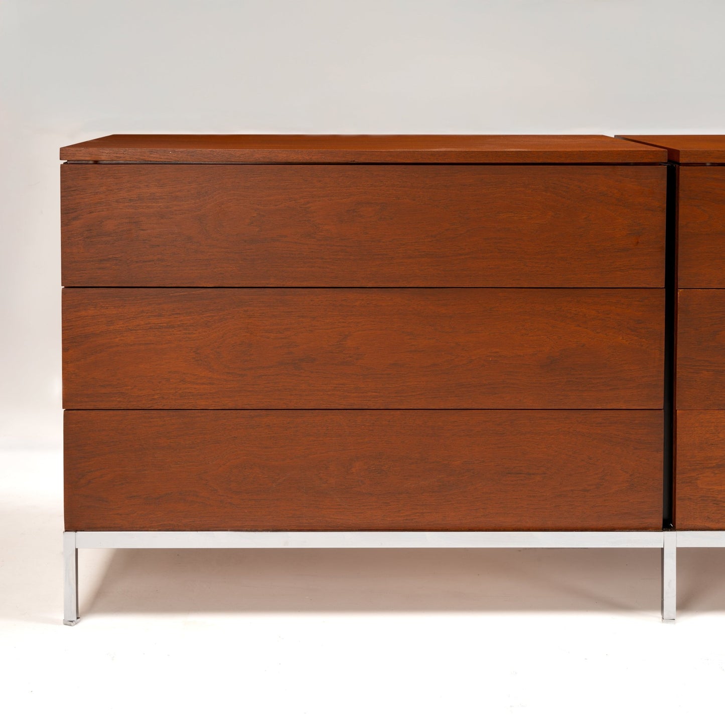 Florence Knoll Walnut Chest of Drawers showing three flush drawer fronts rich walnut grain and polished metal legs in mid century modern furniture style