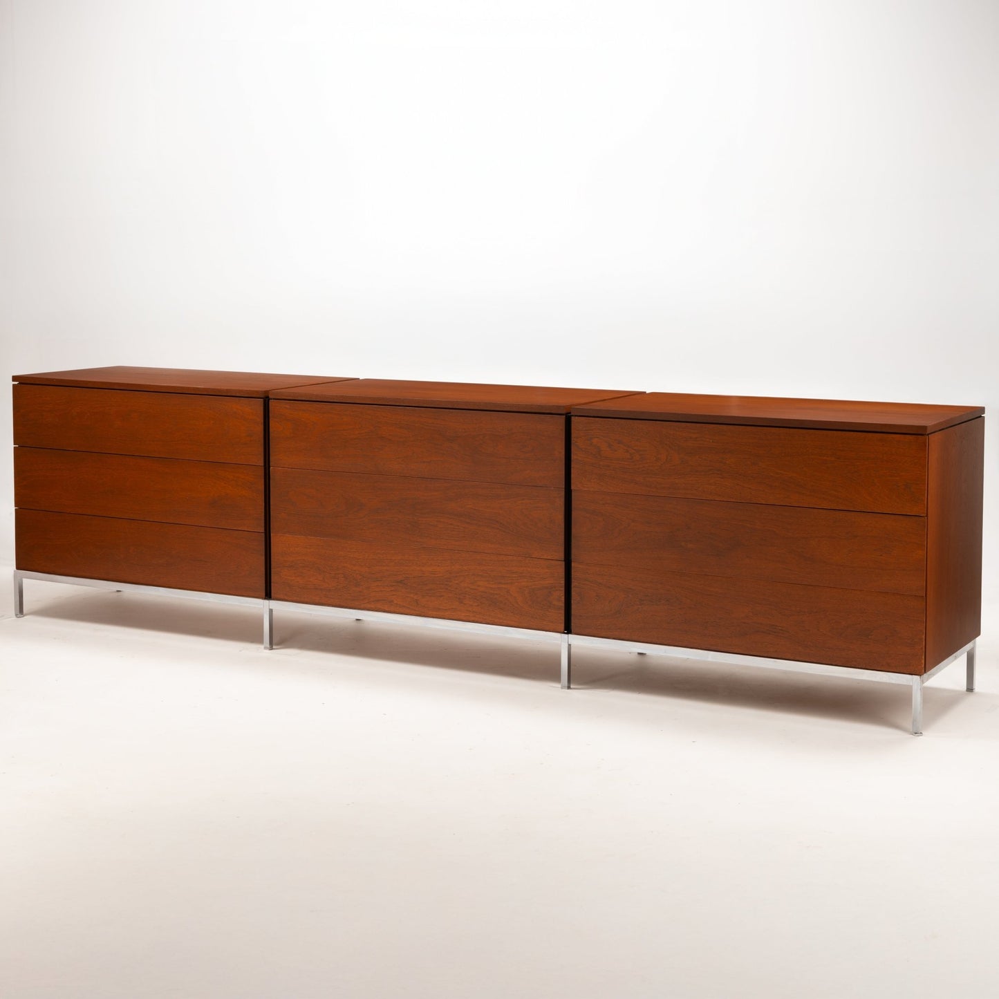 Florence Knoll Walnut Chest of Drawers featuring three cabinet sections rich walnut grain and slim polished metal legs in mid century modern furniture style