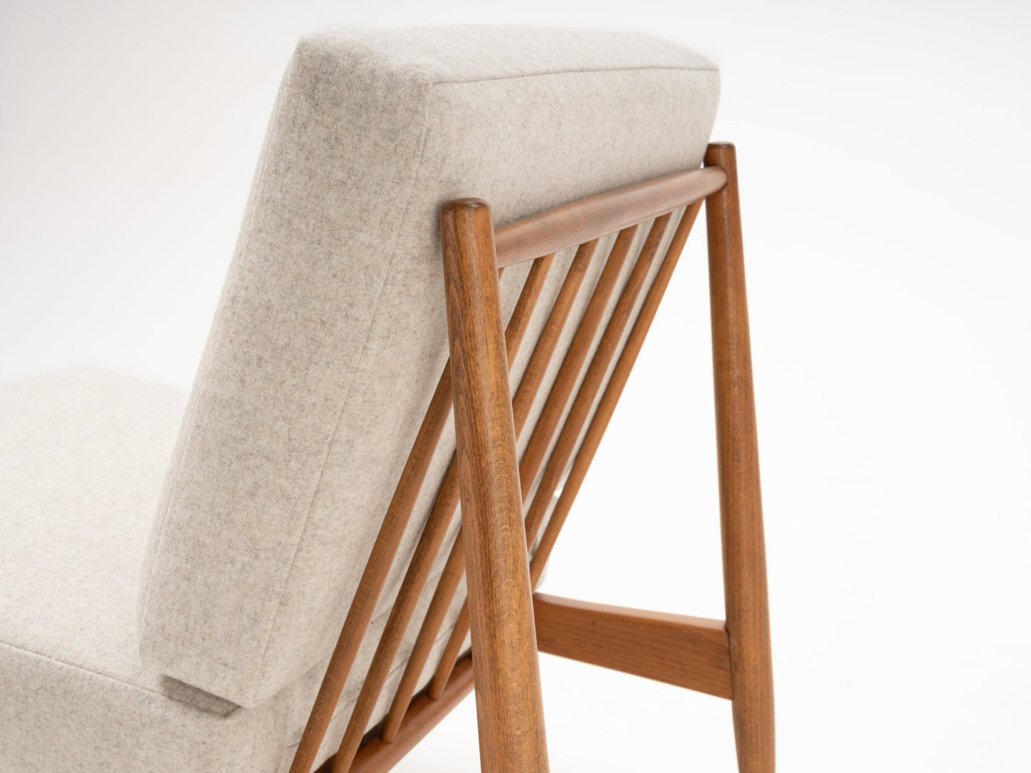 Close-up rear view of Folke Ohlsson slipper chair showing slatted beechwood frame and light grey upholstered back cushion