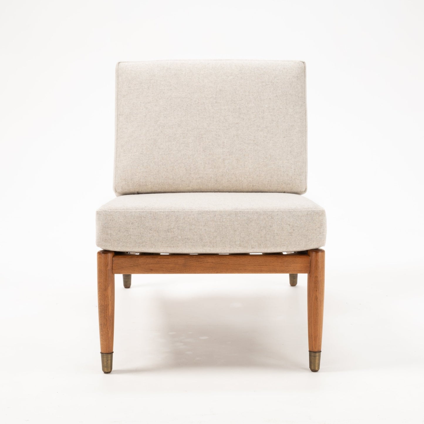 Single Folke Ohlsson slipper chair with beige fabric seat and back on teak and beechwood frame on white background